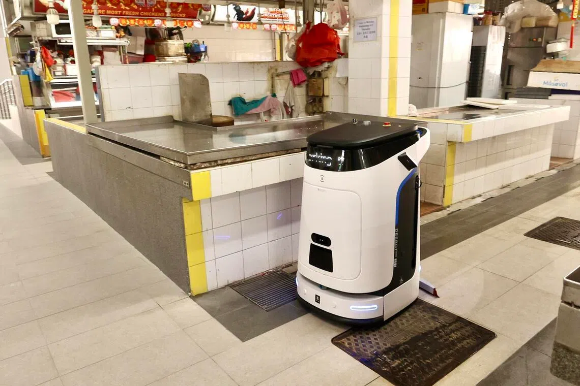 相比现在清洁工洗地的清洁模式，清洁机器人可以节约很多水、能保持地面干爽。（邬福梁摄）