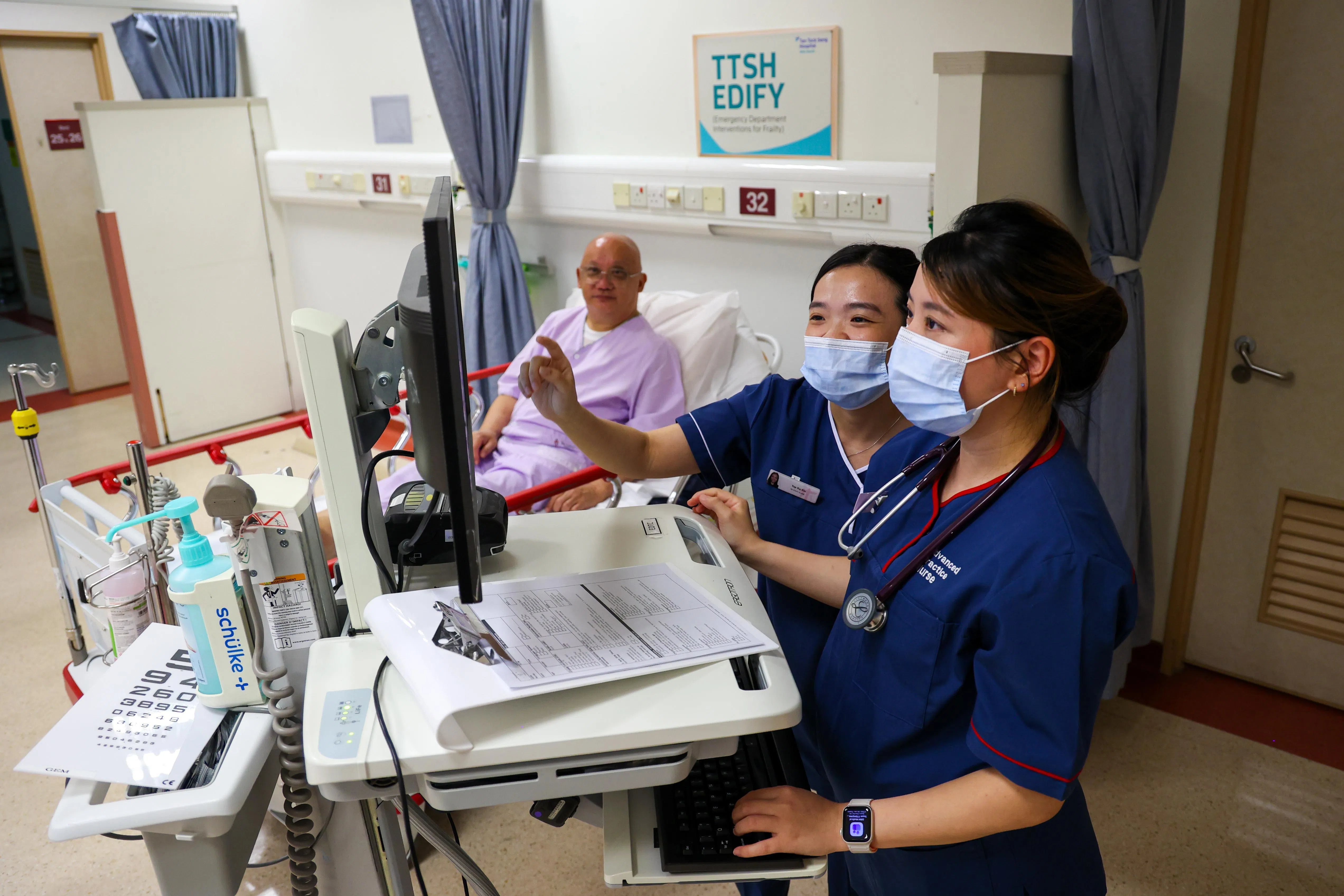 陈笃生医院推行的急诊部衰弱病患干预项目下，老年科高级实践护士黄琬玲（右一）和急诊科老年专科护士叶可欣（右二）在衰弱病患干预病房里，为进入急诊科的病患做检查，再决定是否需要急性住院，或推荐病患接受哪一种适地照护。（林明顺摄）