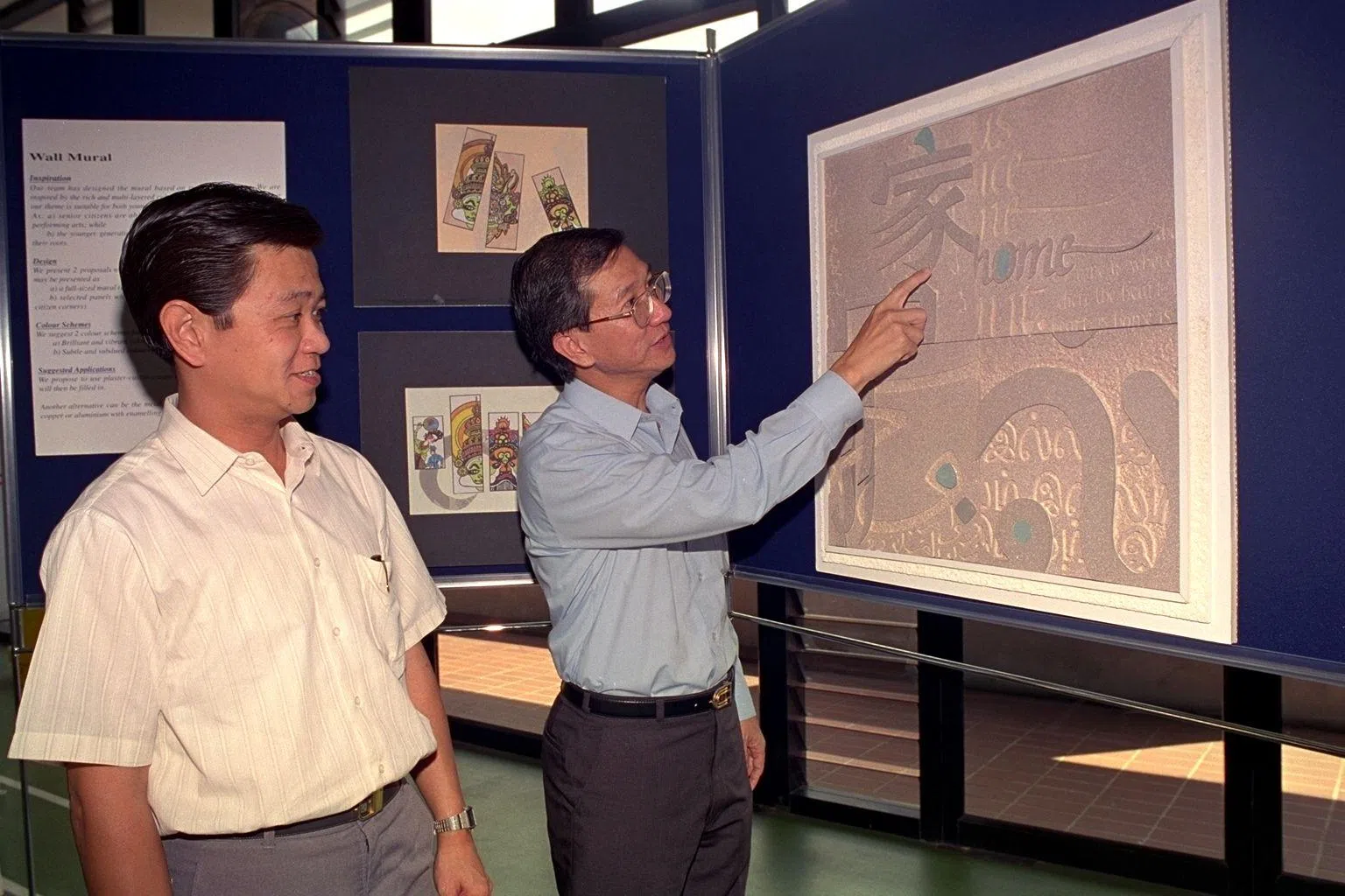 1994年6月27日，时任布莱德岭区议员的吴俊刚（右）向当时的内政部长黄根成介绍富有民族艺术特色的雕花版画。这些雕花版画是碧山实龙岗市镇独具一格的标志。（档案照片）