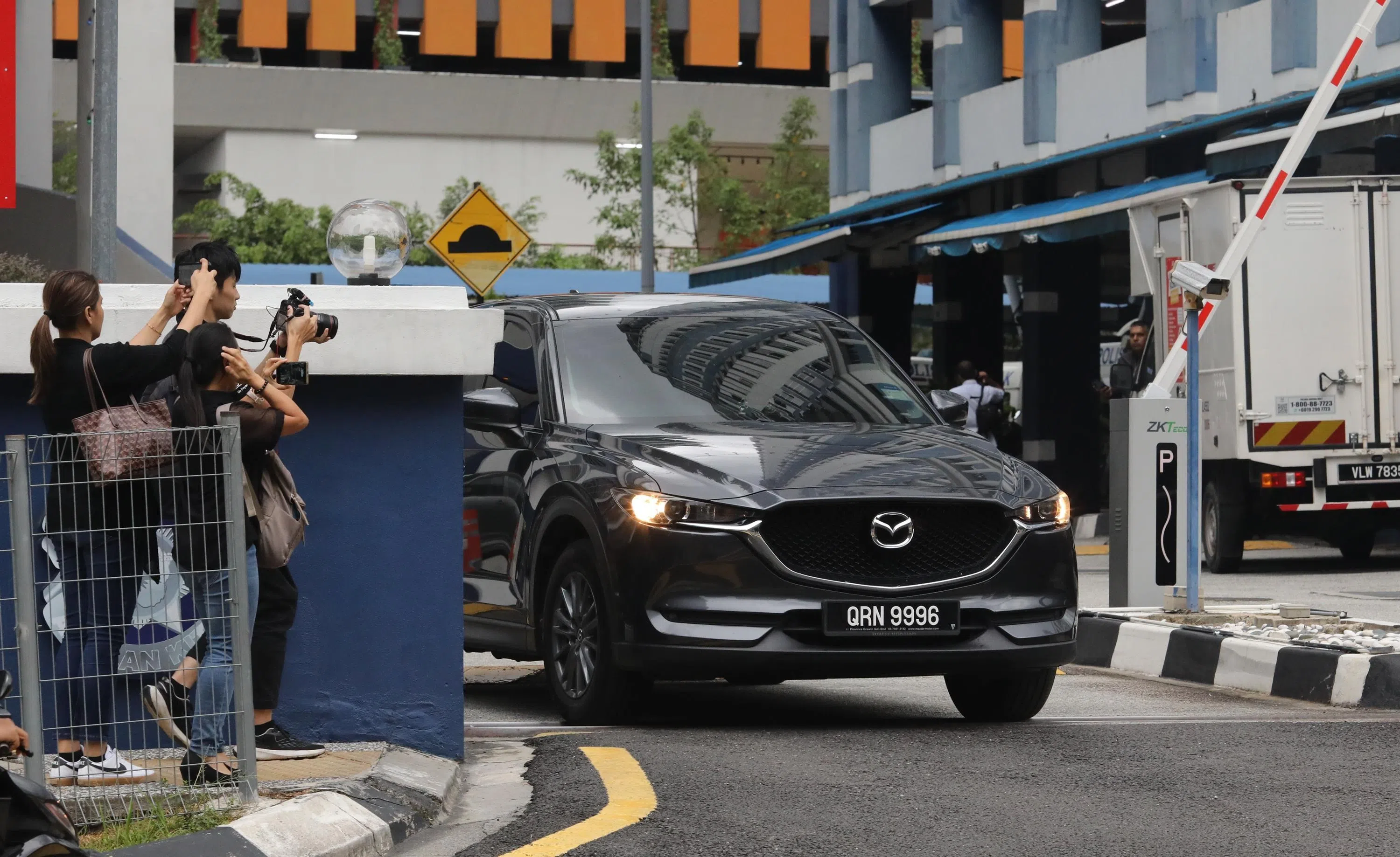 黃明志登车离开警局。（星洲日报提供）
