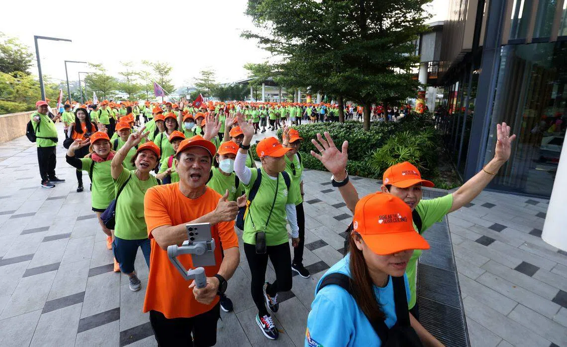 本地导演梁志强（橙衣者）为支持运动，与护联中心合作，邀公众同他领导的晨运团队“老朋友趴趴走”一起步行。（邝启聪摄）