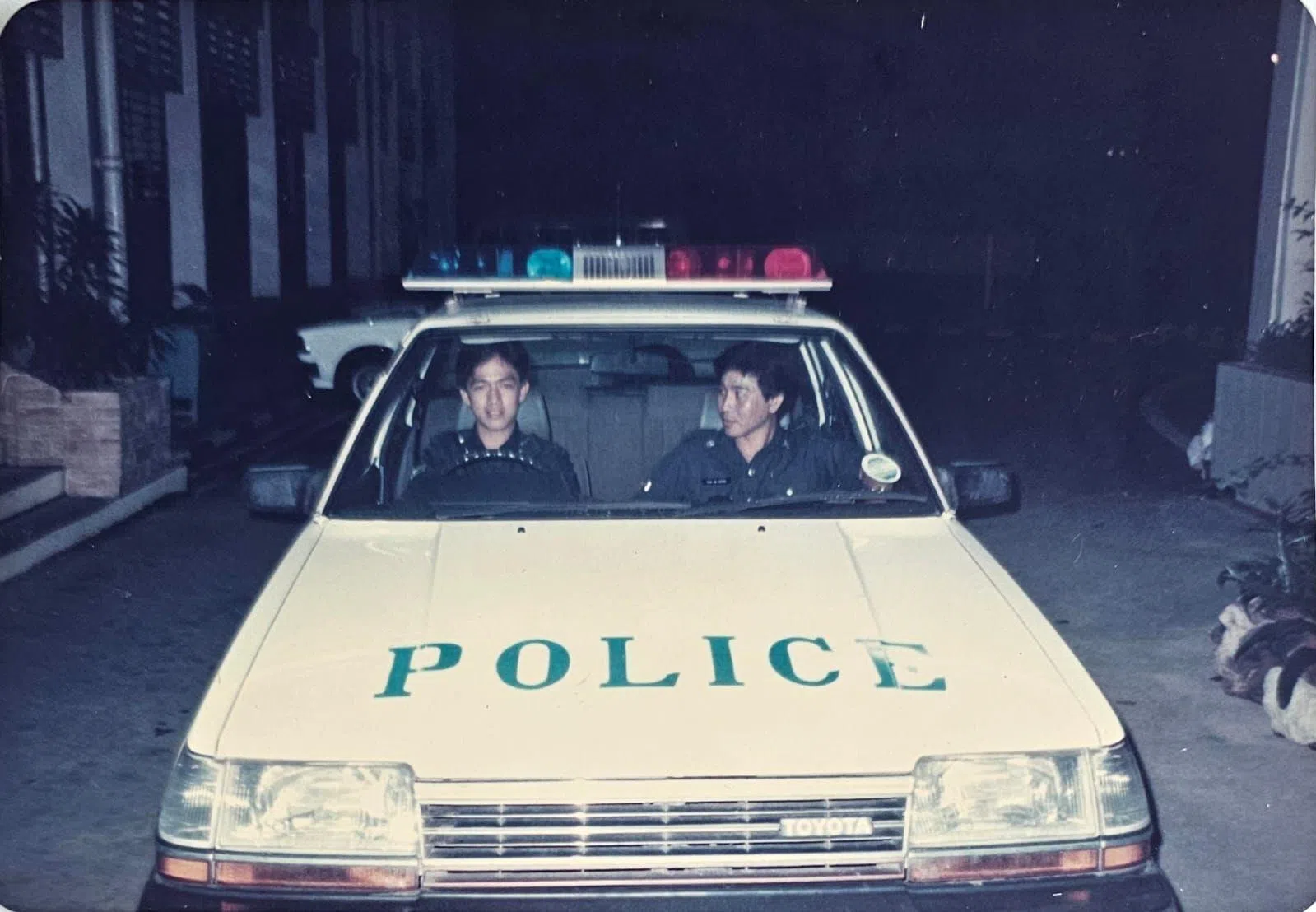傅稏强（右）年轻时，与同僚一起坐警车巡逻。（受访者提供）