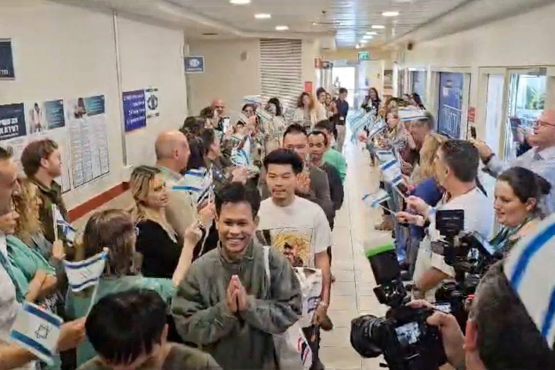 11月29日，获释的泰国人质从以色列的医院出院前，接受着他人的祝贺。（路透社）