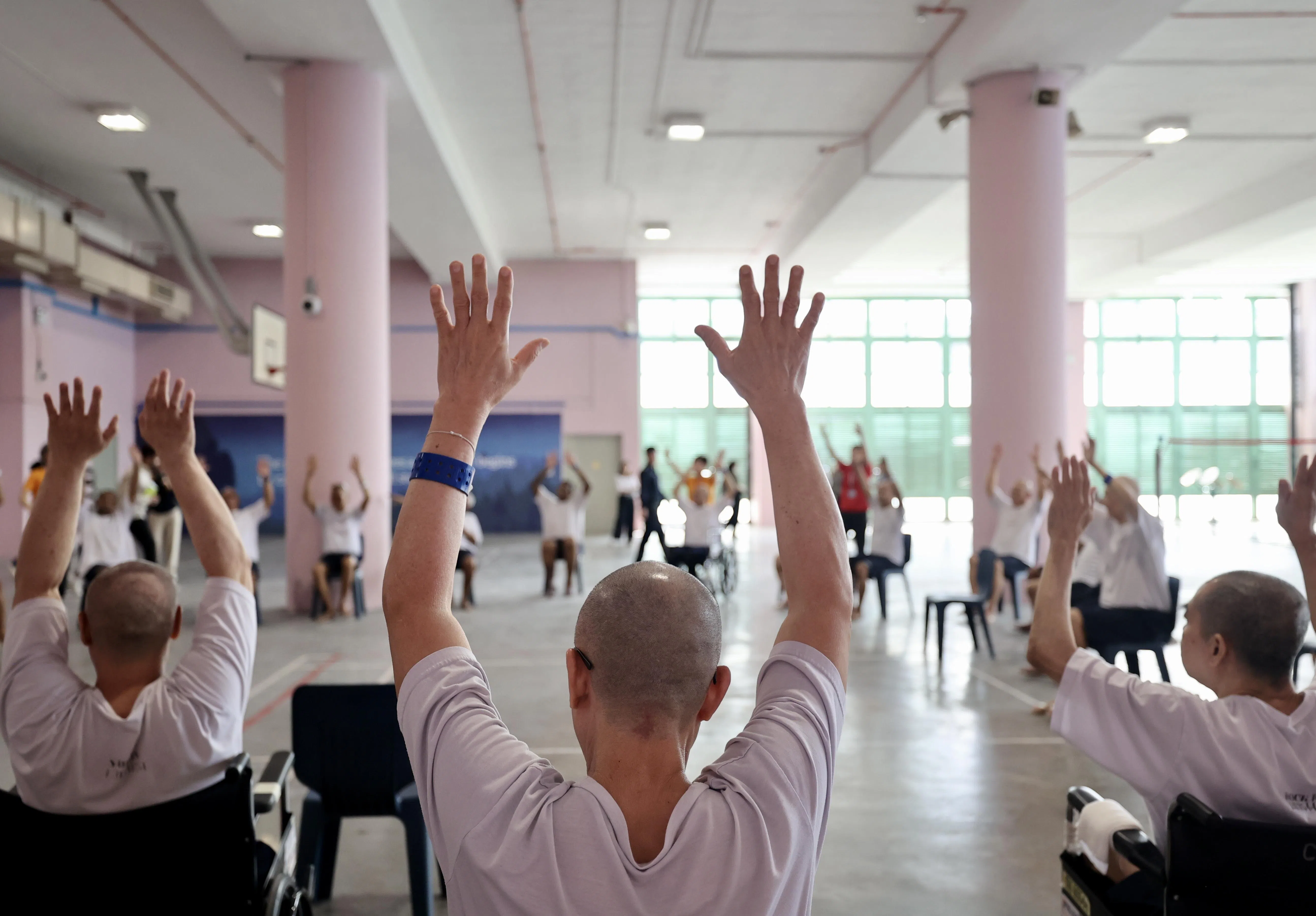 监狱署安排社区伙伴为行动不便的囚犯进行复健操。（邬福梁摄）