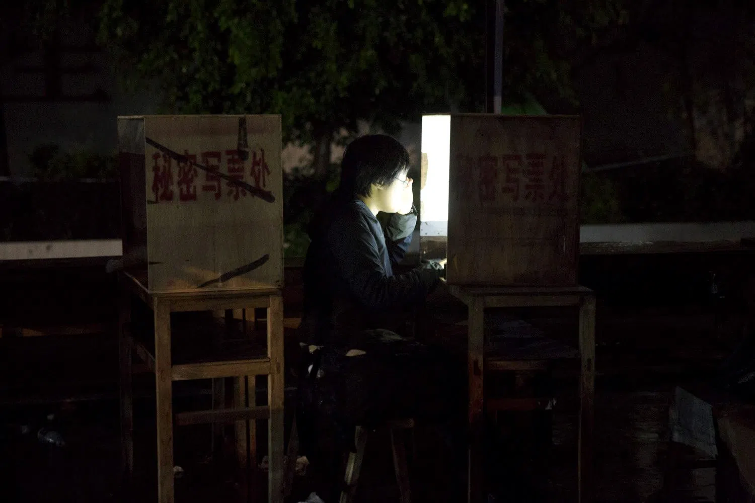 沈泽玮2014年3月采访广东乌坎村委会选举，在秘密写票处写稿。（沈绮颖摄）