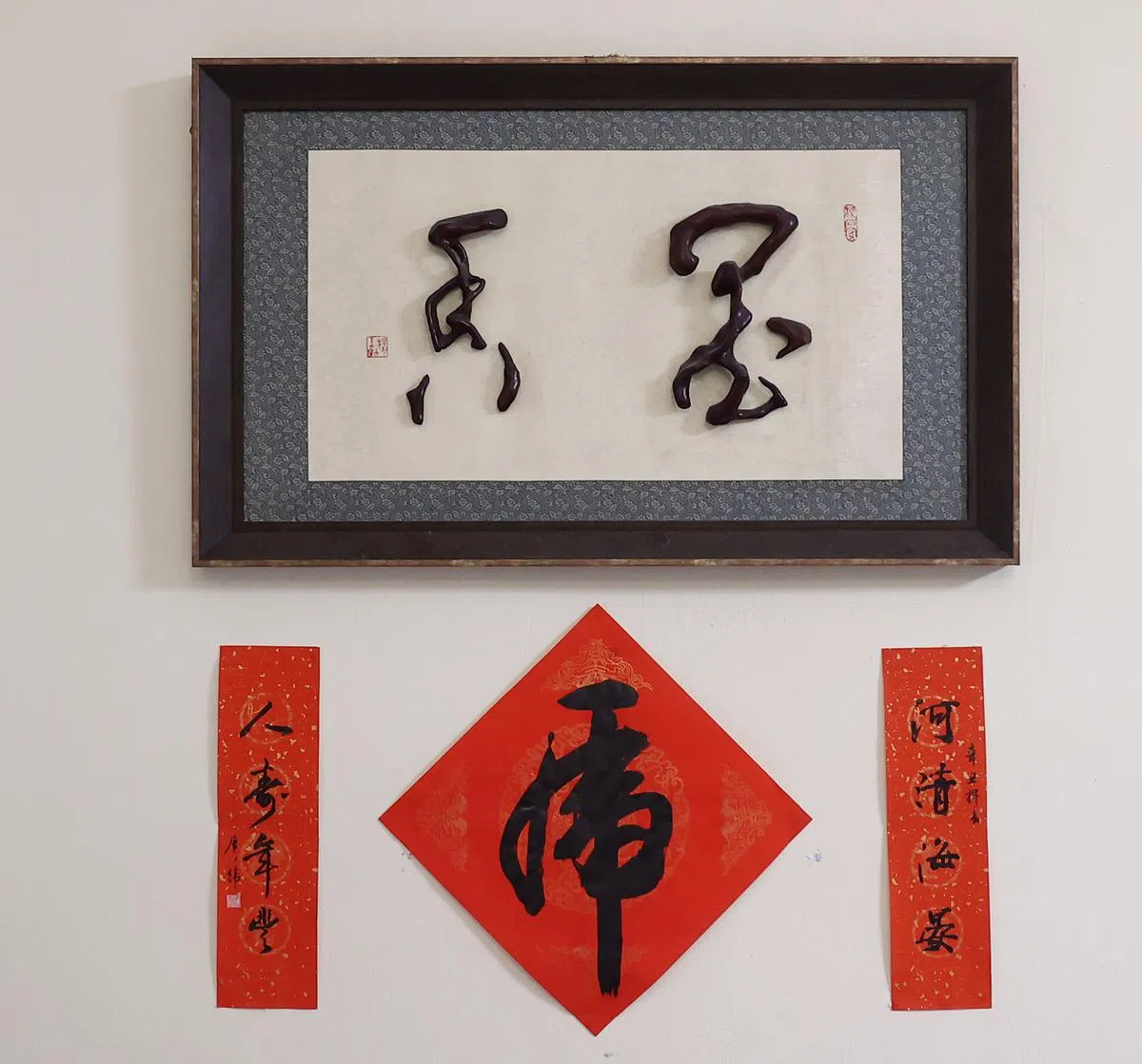 曾广纬书法“墨香”用树根塑成的艺术品以及曾广纬虎年春联。（陈渊庄／摄）