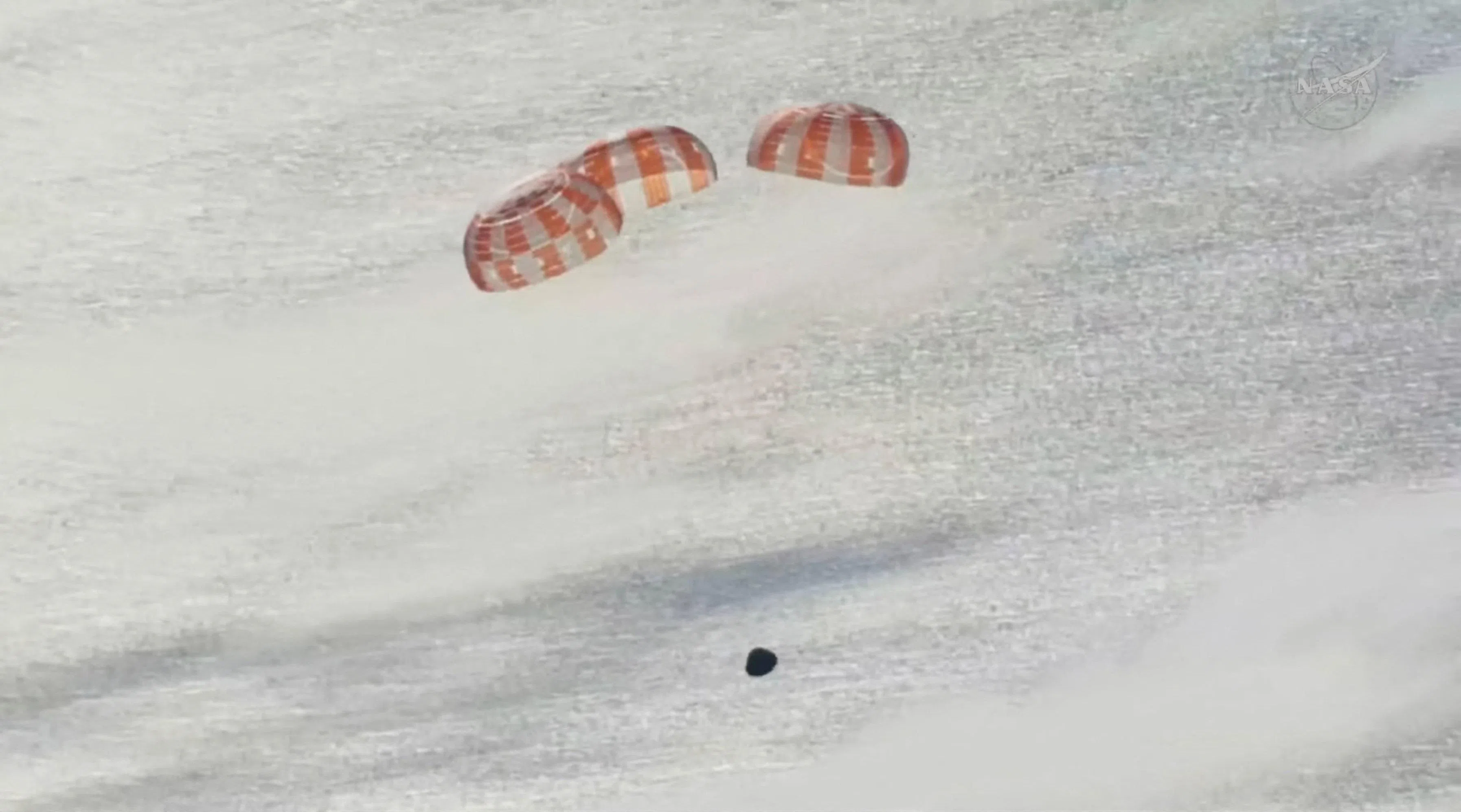 返回舱打开三顶主降落伞，主伞确保飞行器缓慢和安全地着陆。返回舱有多套降落伞，确保即使一个减速伞、一个主伞或其他降落伞部件发生故障时，宇航员仍能安全着陆。（路透社）