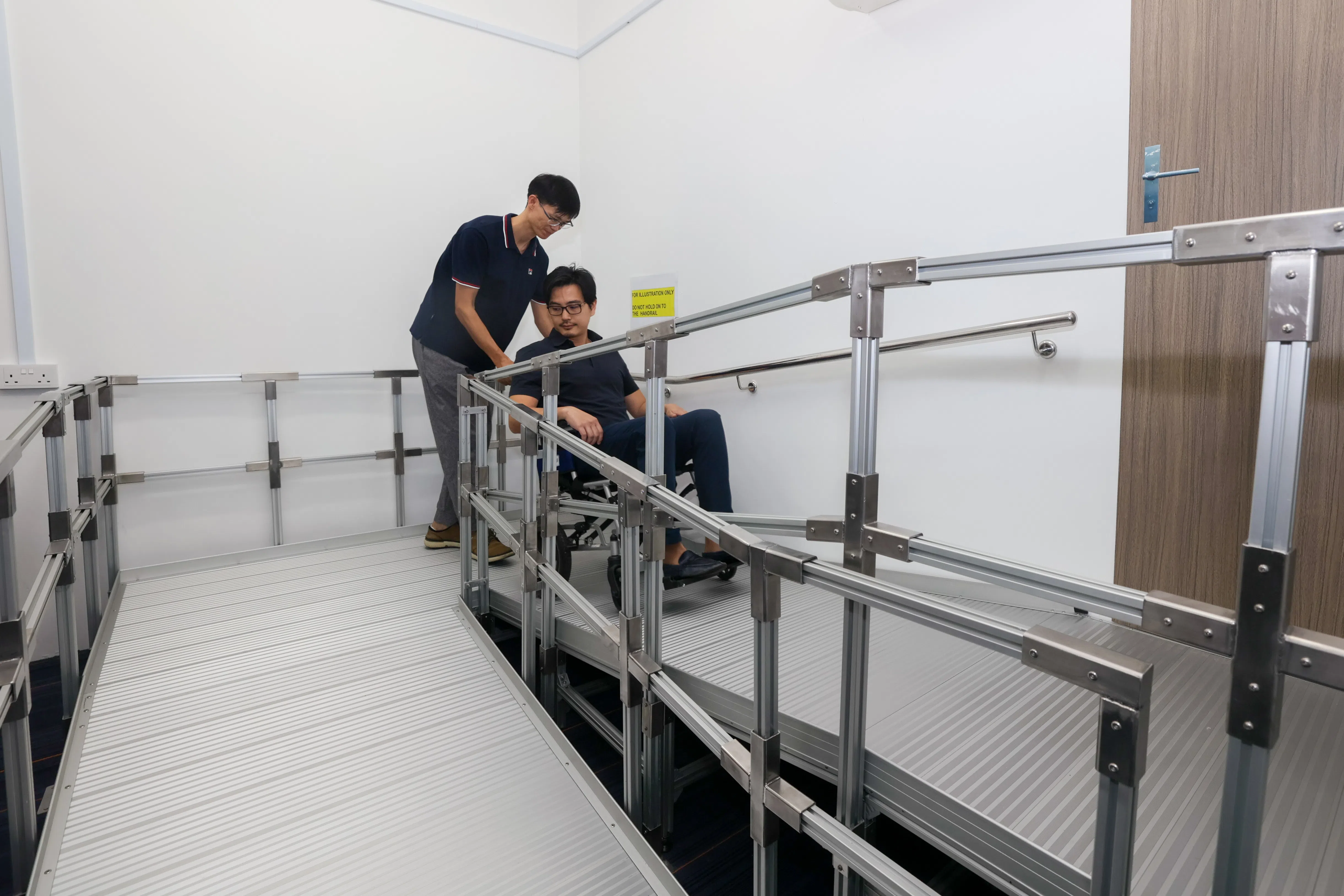 这类新型斜坡道比较长，且有拐弯处，以便维持平缓的坡度，让坐轮椅的年长居民可以安全进出家门。（卓祾祎摄）