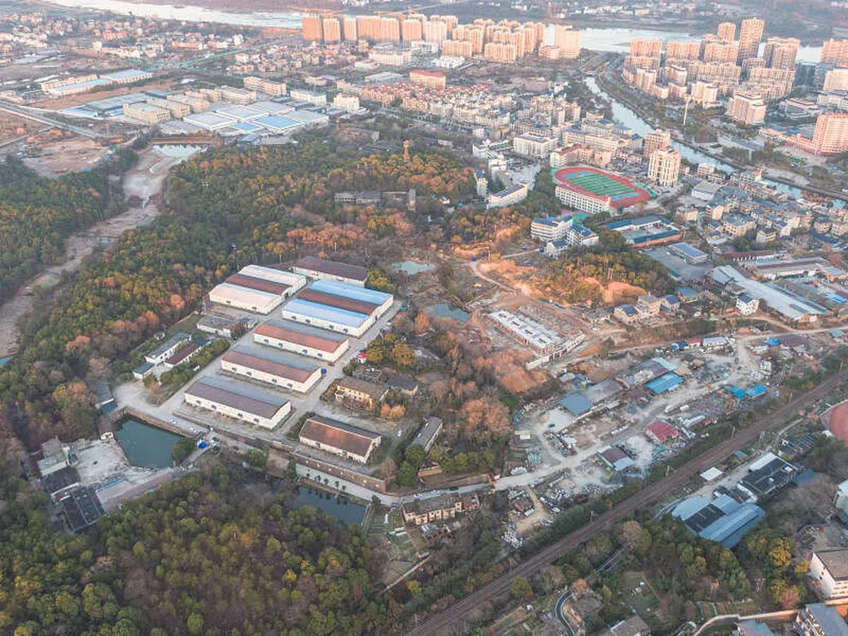 图右上角操场区域为胡鑫宇就读的铅山县致远中学，图左下角仓库建筑群为尸体发现所在区域。（中新社） 