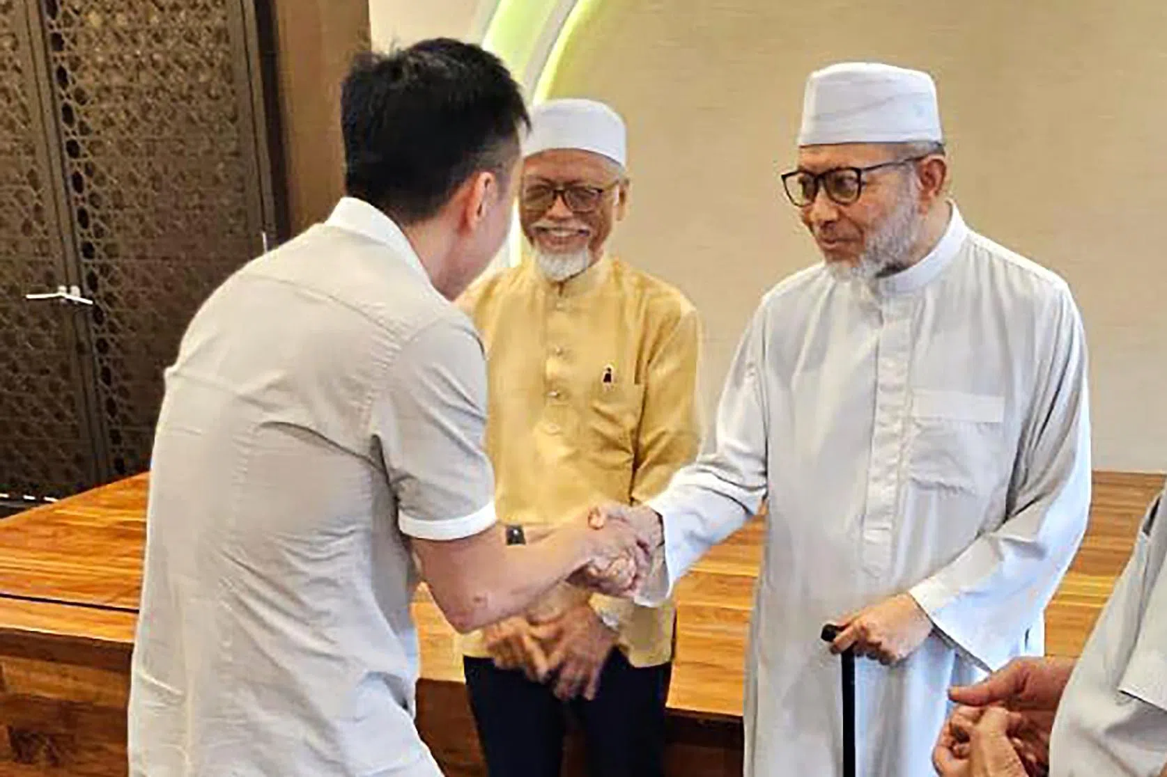 郑恩里（左）与回教宗教师帕斯尼·穆兰（中，黄衣）和穆罕默德·哈斯比在尤索夫伊萨回教堂会面，解释他在脸书发文的原意。 （取自郑恩里脸书）