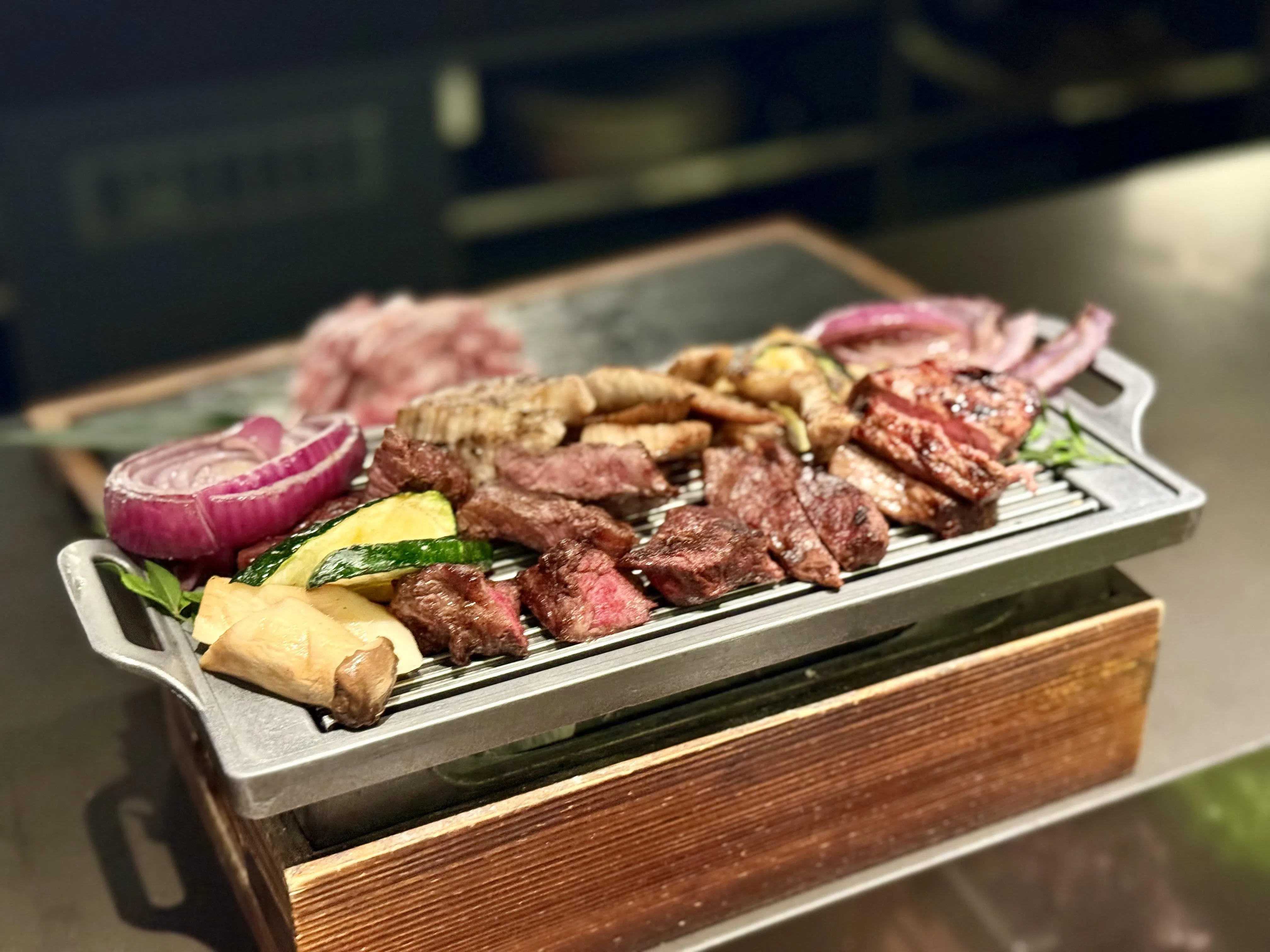 店员把牛肉和猪肉烤好后，所有生菜、小菜、蒜片，以及调味料也一并上桌，建议先裸吃肉品，感受其本味，再用生菜包着组合不同配料享用。（叶晓虹摄）