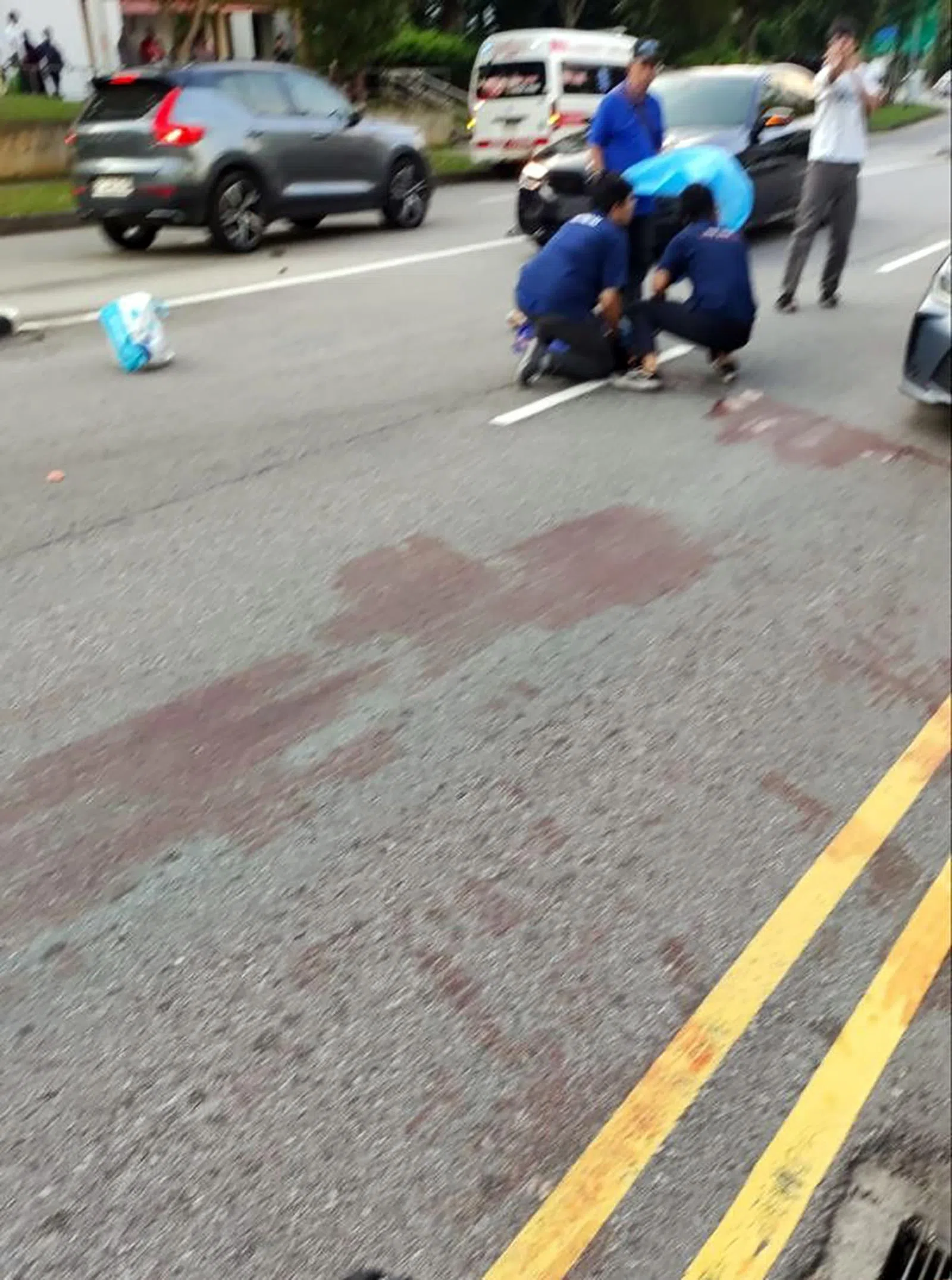 死者过马路遭撞飞后，路上血迹斑斑，医护人员事后赶到现场救援。（档案照片）