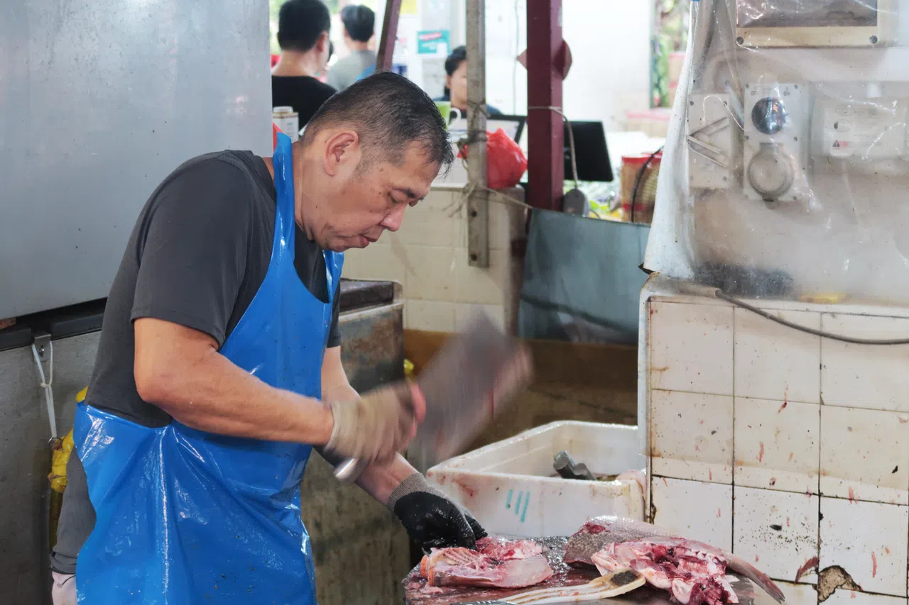 鱼贩蔡进业一边头也不抬地处理生鱼，一边对记者说，近来一些鱼类价格上涨超过一倍。（张俊摄）