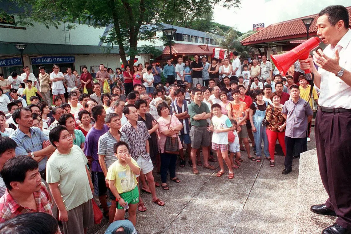 宏茂桥1道第341座湿巴刹及小贩中心2001年1月7日凌晨发生火患，时任副总理李显龙（右）上午到场巡视灾情，并亲自向小贩讲解应对措施，例如设立临时巴刹，确保小贩生计不受太大影响。（档案照片）