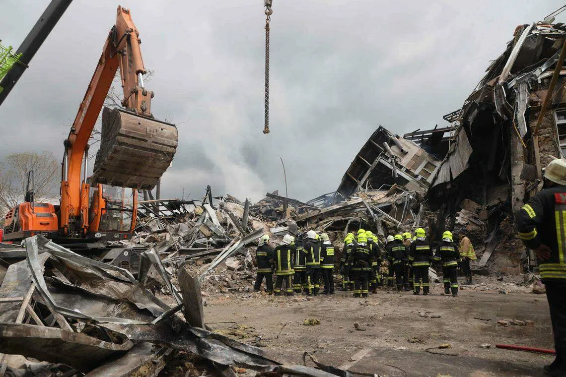 7月20日，敖德萨市一座行政大楼被俄军炮弹击毁后，消防人员在废墟前展开救援工作。（法新社）