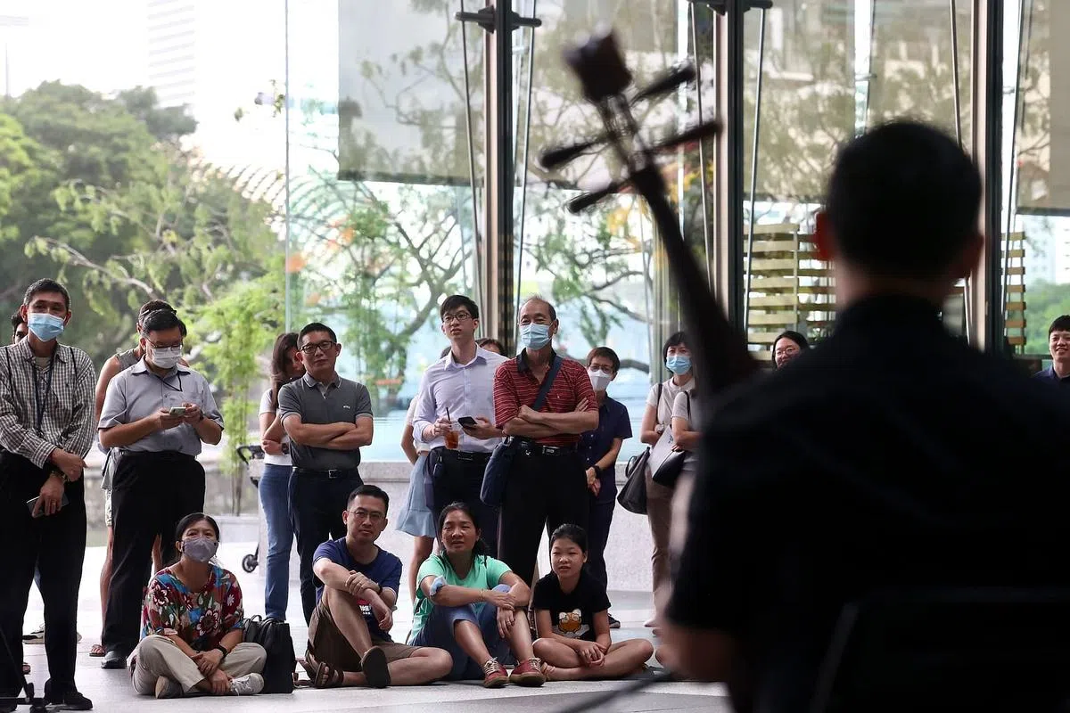 不论是一家大小、上班族或退休人士，都驻足聆听悠扬的华乐曲目，甚至席地而坐，感受音符所诠释的汉字。（陈斌勤摄）