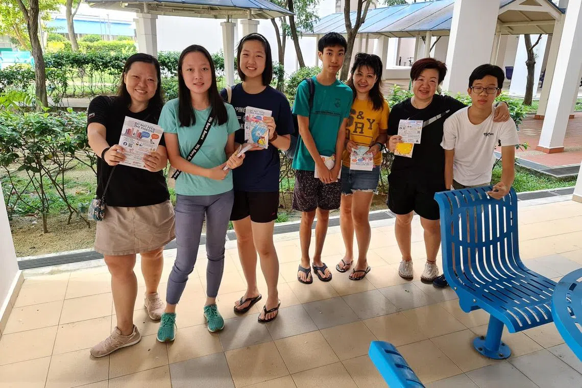 卓慧玲（右二）和For Our Kampung的部分成员自行设计宣传单，挨家沿户进行宣导，劝告居民不喂食鸟类、妥善处理垃圾和剩食。（受访者提供）