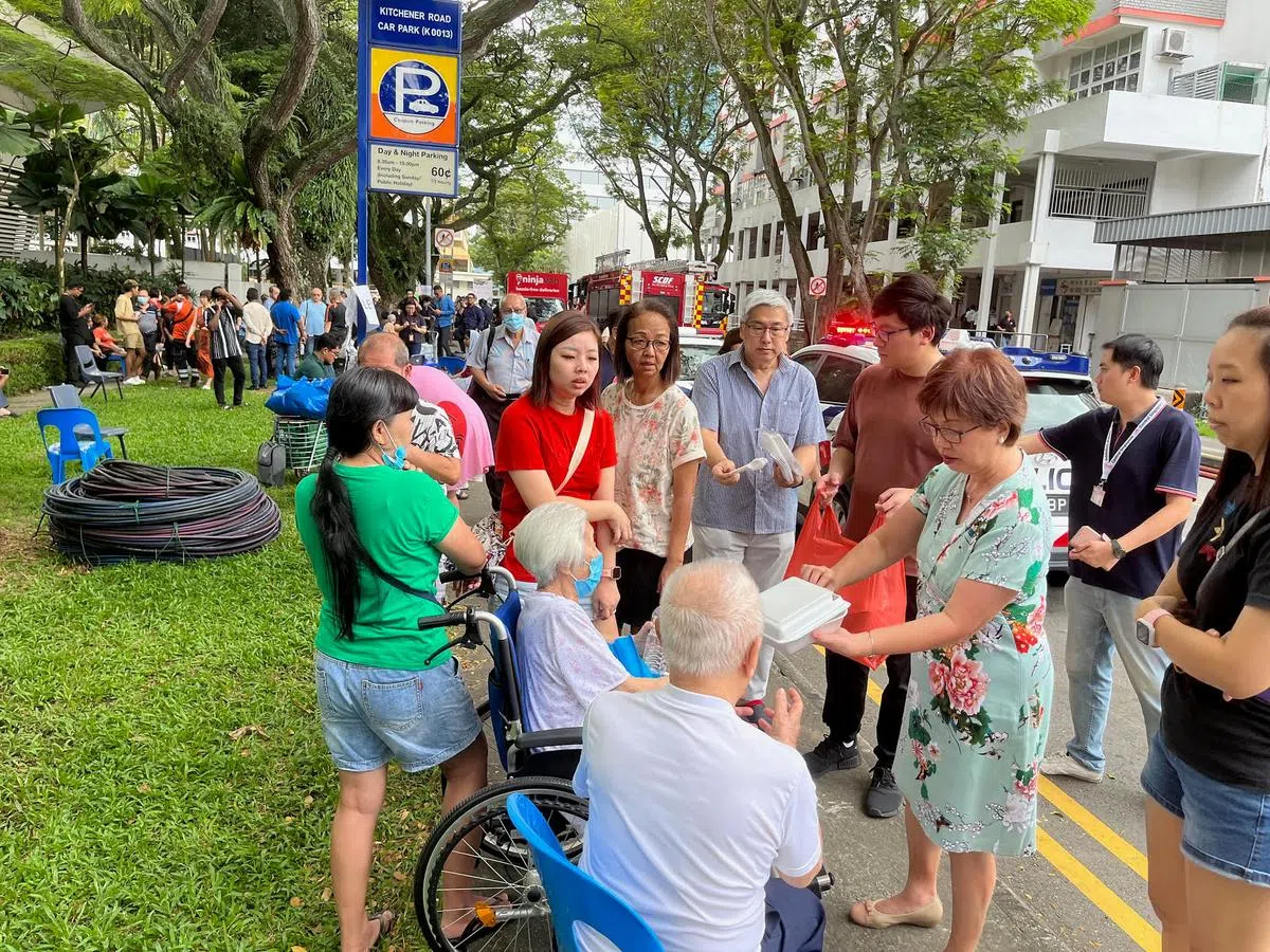议员潘丽萍（右三）到现场分发午餐给受影响居民。（吴睿明摄）