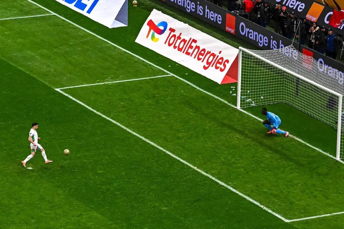 勺子罚球是一种特殊的罚球踢法，罚球者只是轻踢足球下方，让足球呈抛物线状飞向球门中间，有时会让门将做出错误扑救。但迪亚斯（左）的罚球过于绵软无力，让塞内加尔门将门迪（右）站在原地就将球没收。（法新社）