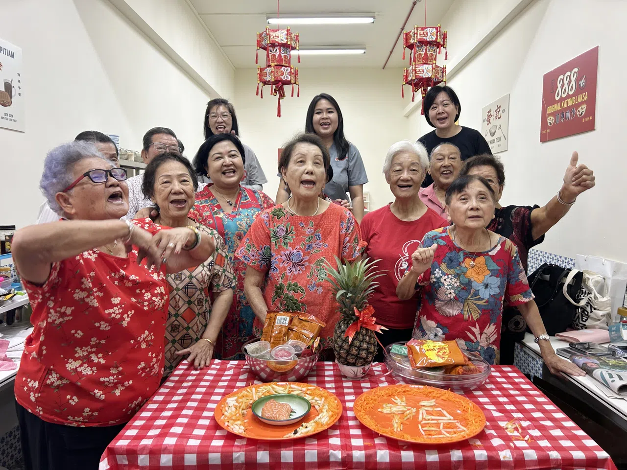 今年农历新年，陈依琳（后排中间，灰色上衣）与年长者一起在乐龄俱乐部捞鱼生，其乐融融。（受访者提供）