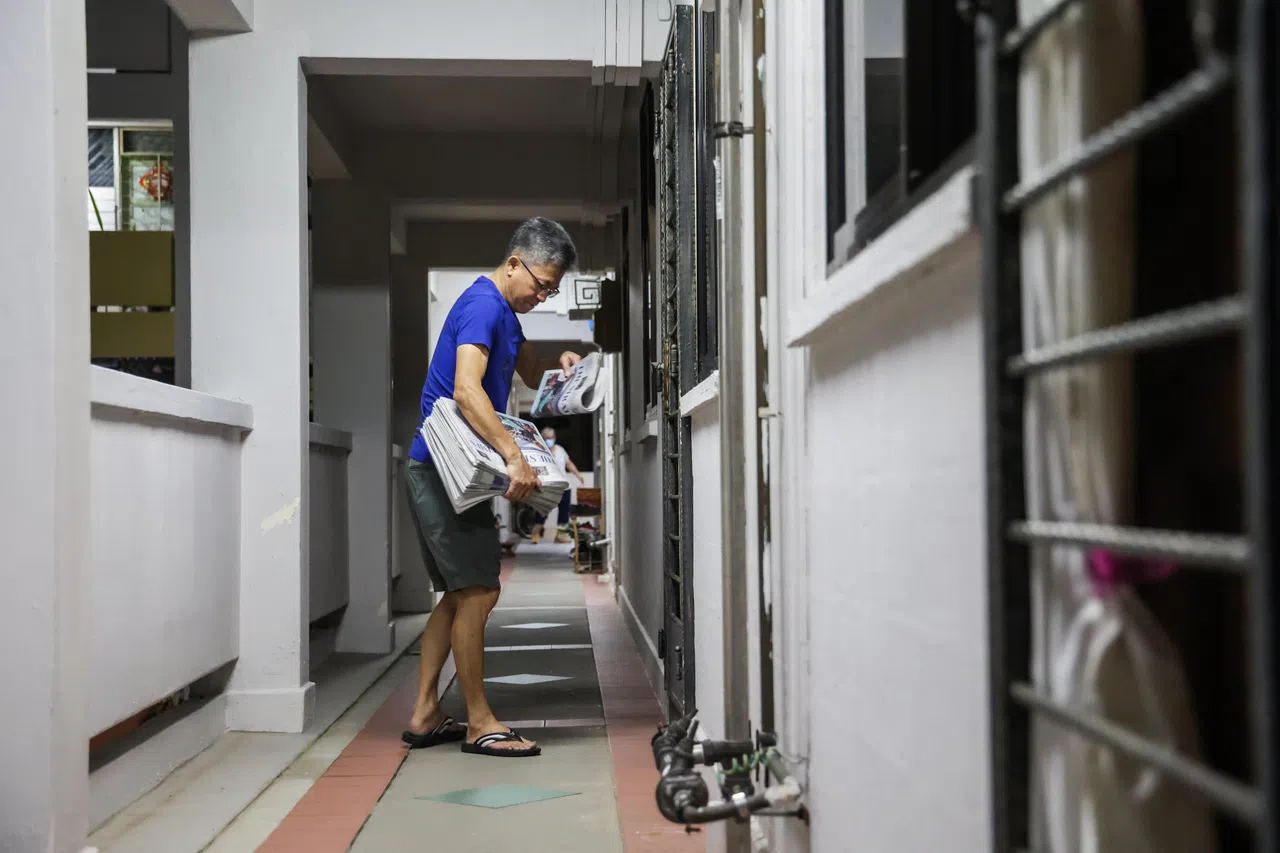 防疫阻断措施期间，派报员随身带着准证，每天把新出炉的报纸送到订户家门口。（白艳琳摄）