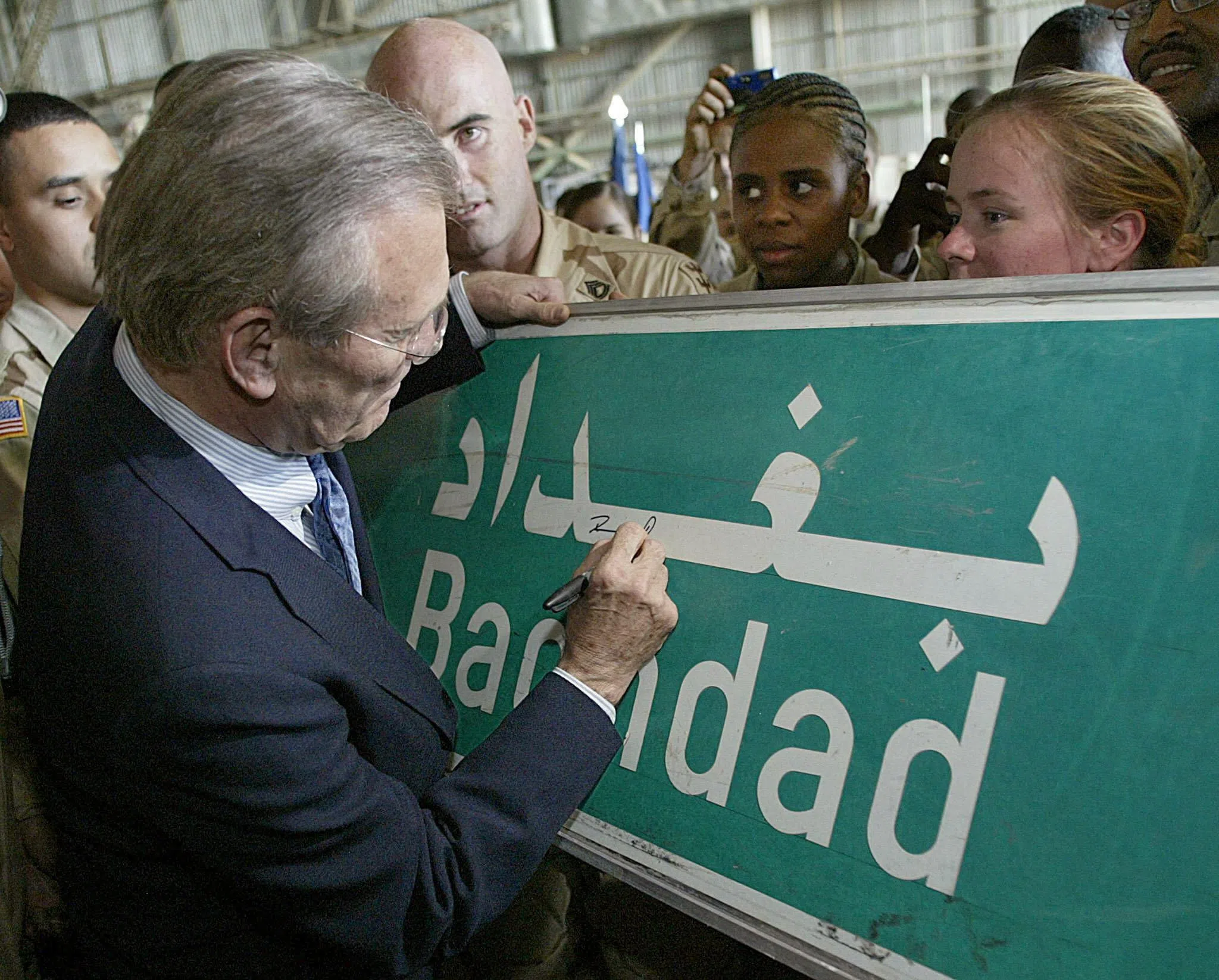 美国2003年入侵伊拉克，时任国防部长拉姆斯菲尔德（Donald Rumsfeld）同年4月30日到访伊拉克巴格达国际机场，与驻地美军会面，并在一块写着“巴格达”的路牌上签名。（路透社）