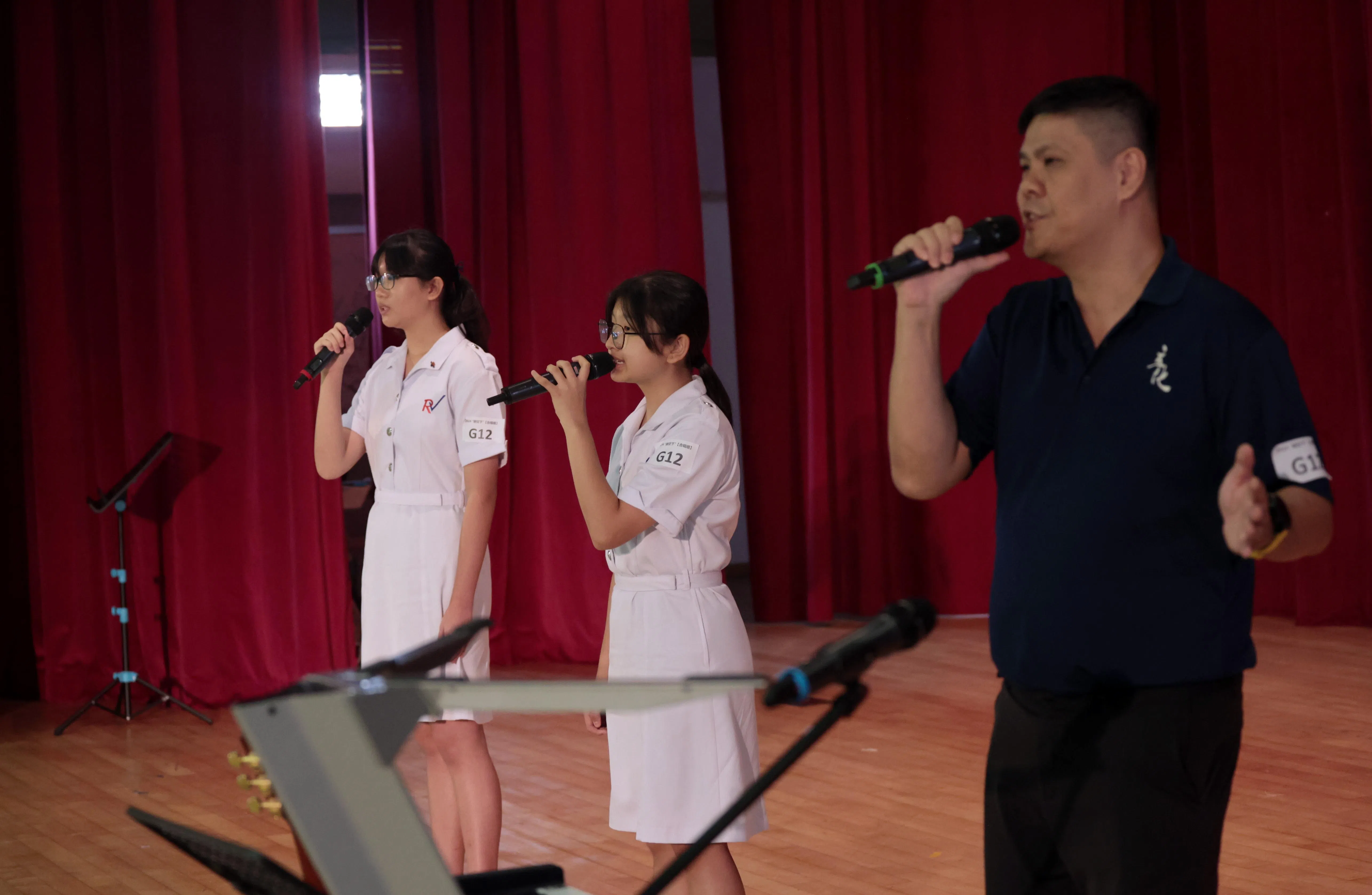 “飞扬小组”的邱譞满（左）、郭芸廷（中）与老师柳公凯（右）合唱《如果你不小心想起我》，留下美好的师生回忆。（梁麒麟摄）