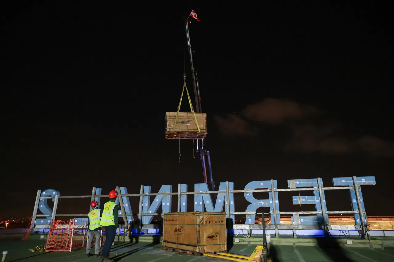 箱子到顶层后，另一组工作人员会接手拆货和安装太阳能板。（李冠卫摄）