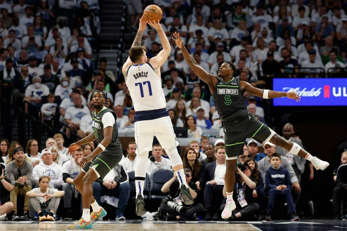 东契奇（77号）本场比赛获得36分、10个篮板、五次助攻，灰狼球星爱德华兹（5号）则进账28分。（法新社）