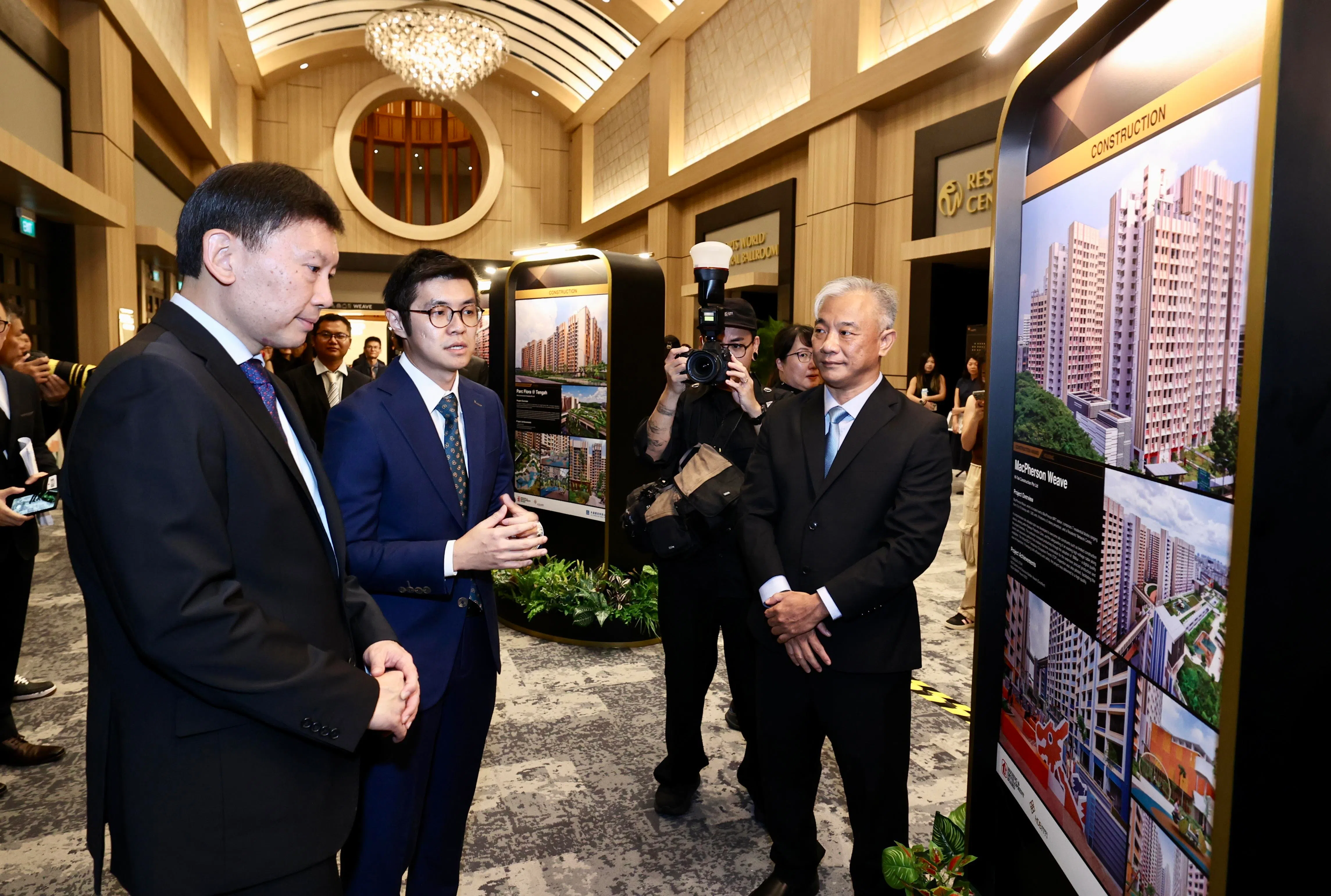 国家发展部长徐芳达（左一）在建屋局颁奖礼晚宴开始前参观展览，了解获奖的30个预购组屋项目的更多细节。（周国威摄）