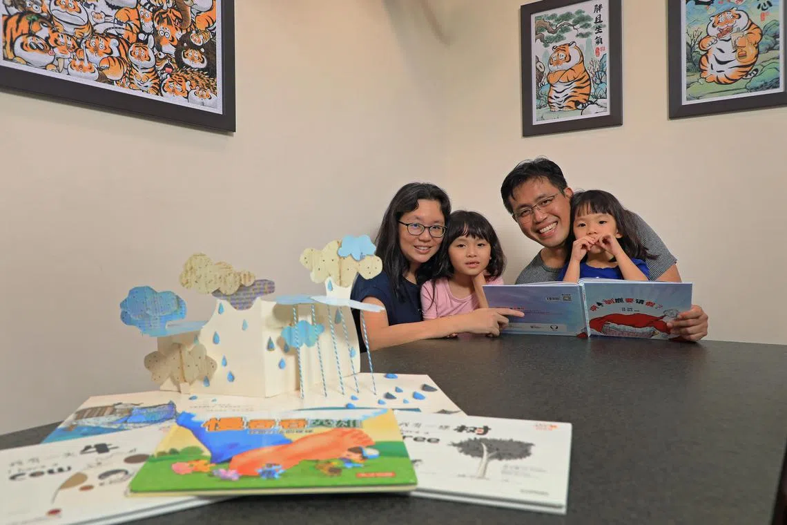 李治贤夫妇希望孩子多接触中文，所以尽量选择不附汉语拼音的绘本，陪伴孩子阅读。（何炳耀摄）