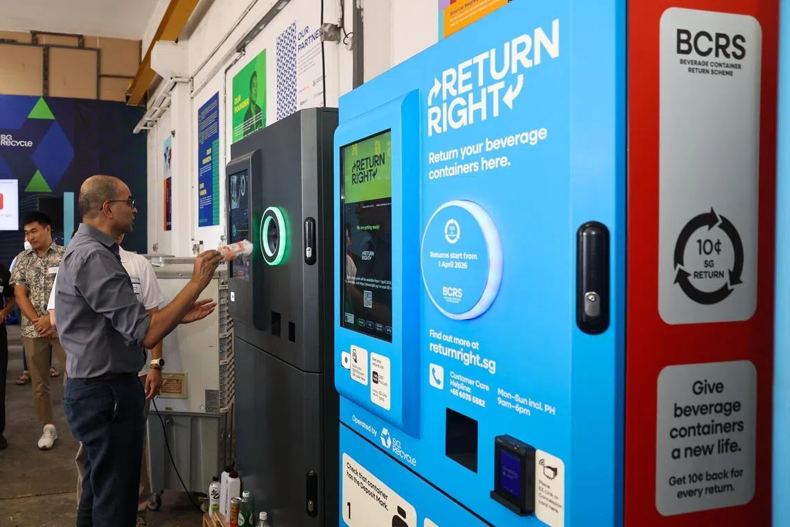 教育部兼永续发展与环境部高级政务部长普杰立医生，在SG Recycle推介活动上，试用饮料瓶罐回收机。（陈渊庄摄）