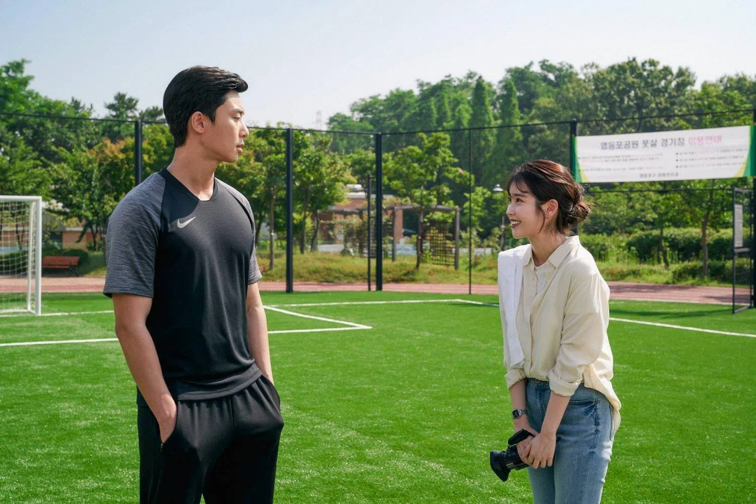 朴叙俊（左）扮演足球员兼露宿者球队的教练，IU诠释鬼马的纪录片导演。（Netflix提供）