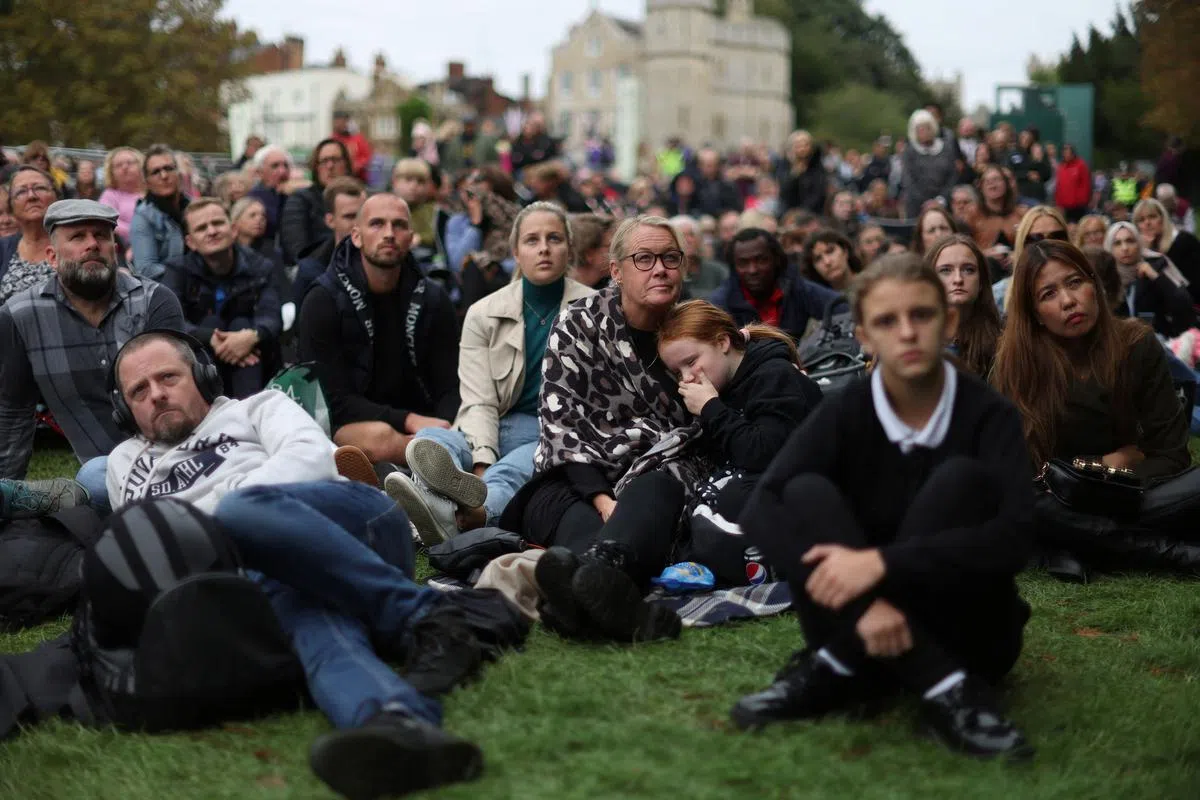 温莎城堡外，民众收看女王国葬直播。（路透社）