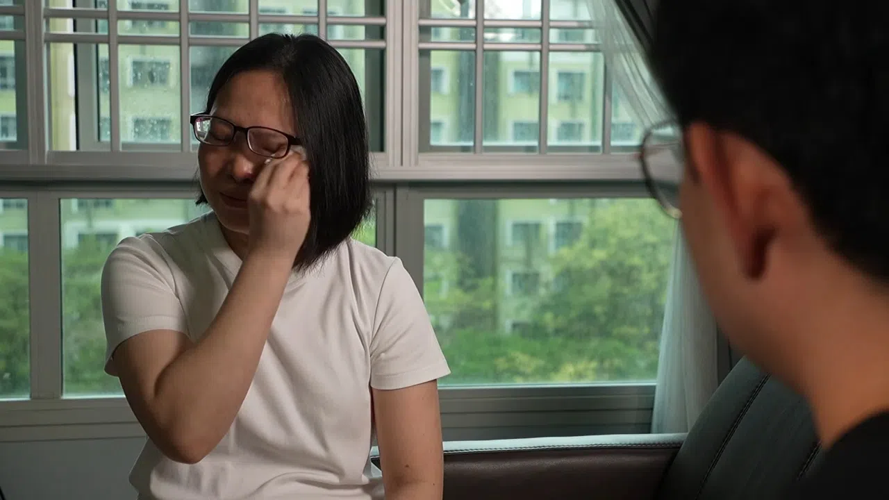 访问过程中，丽敏谈及过往时多次落泪，两个女儿在旁给予她许多勇气和支持。（视频截图）