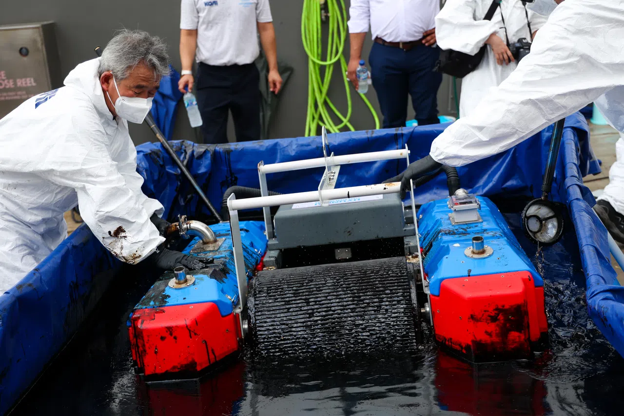 在现场示范中，工作人员展示KOBOT机器人如何把油污吸附在棘轮上，它每小时可以清除0.2吨到0.5吨的油污，每个收集袋可装载约0.7吨的油。（林明顺摄）
