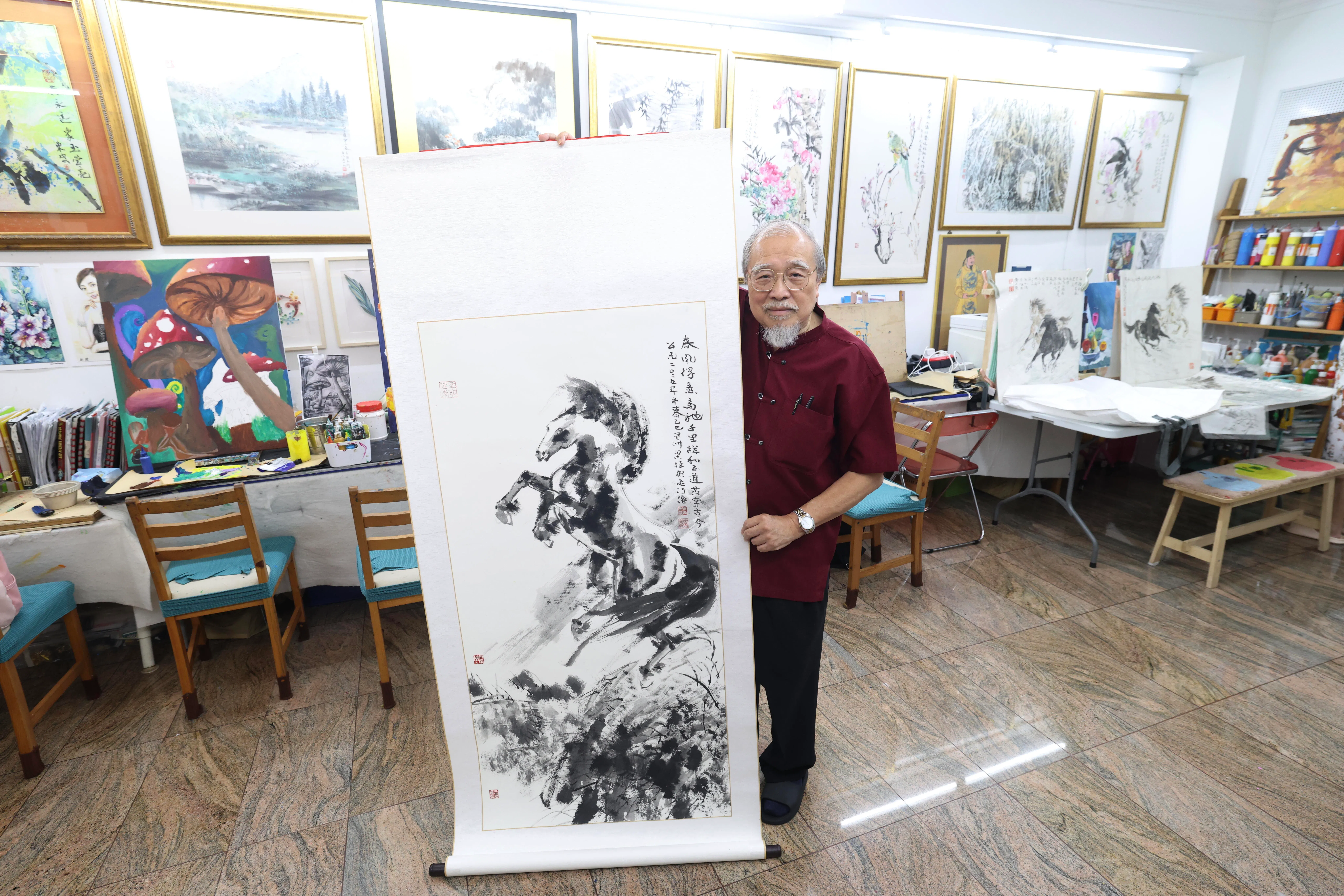 本地画家梁振康，1月17日在三友画苑向《联合早报》记者展示上月完成的奔马水墨画。（郑一鸣摄）