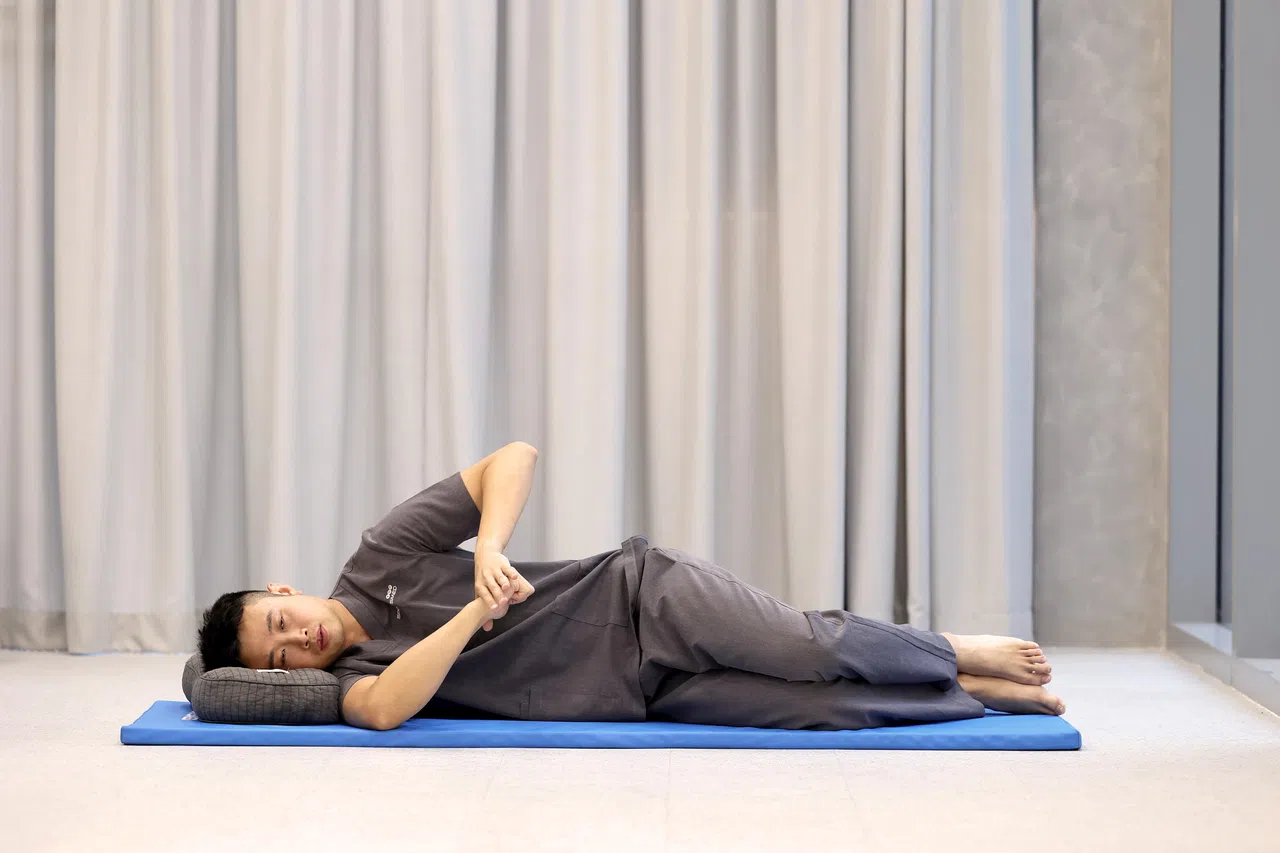 右手肘弯曲，右前臂向下移动，直到极限。左手轻轻施压在右手上，保持适度拉伸感。（关俊威摄）