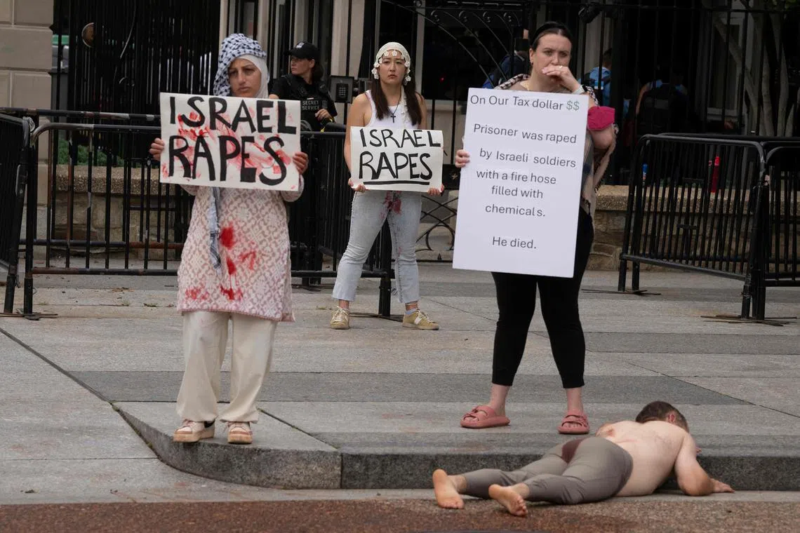 7月22日在白宫外，支持巴勒斯坦的示威者高举标语，指控以色列军在加沙涉及性虐待。（法新社）