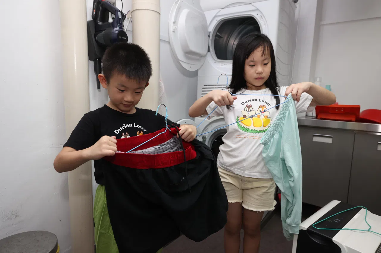 俞聿宣（右）喜欢当小老师，教弟弟聿勋如何晒衣、挂衣服。（唐家鸿摄）