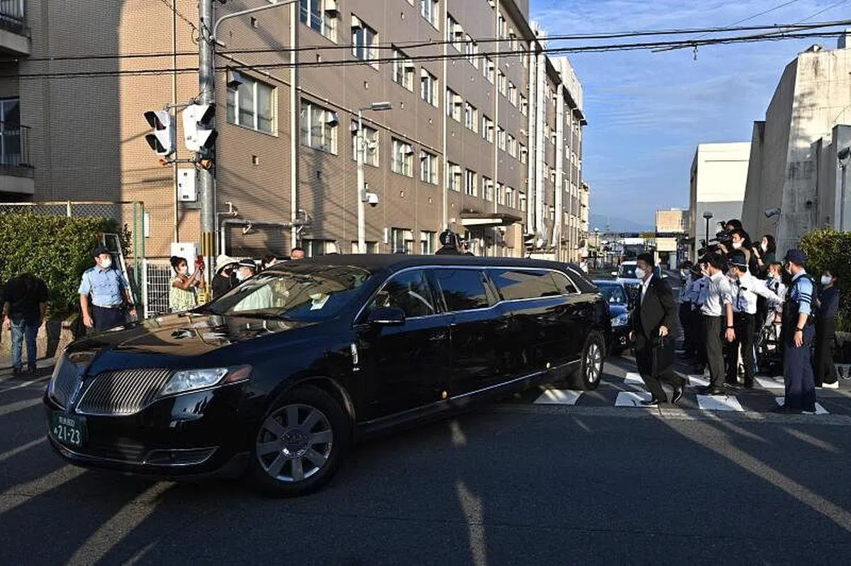 一辆相信载有安倍晋三遗体的车星期六早上6时（新加坡时间早上5时）前离开了医院，（法新社）