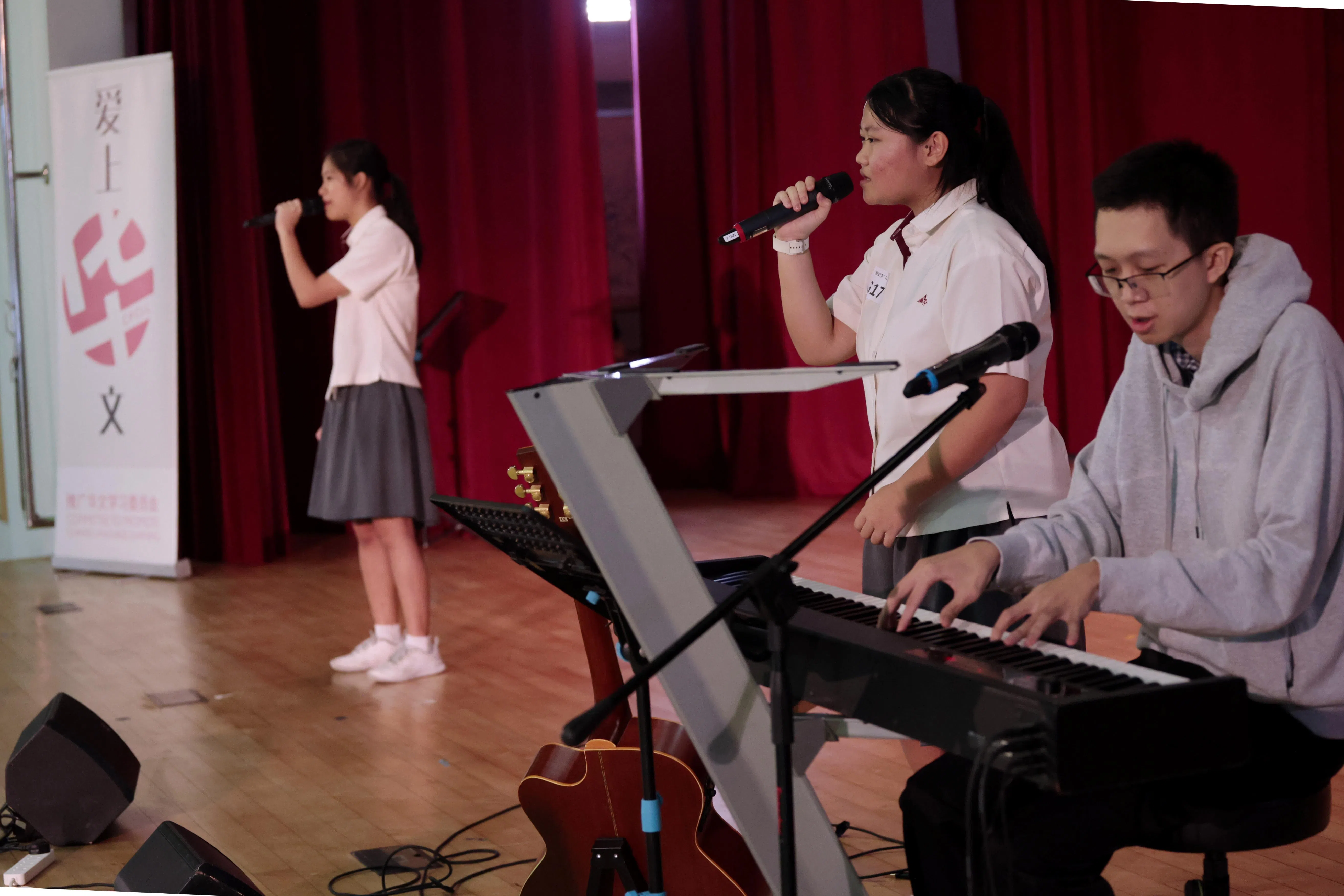 “泛黄的书签”组合黄枥仟（左）和黄纾慧（中）演唱《回忆与未来的对话》，而老师吴思汉（右）为她们弹琴伴奏。（梁麒麟摄）