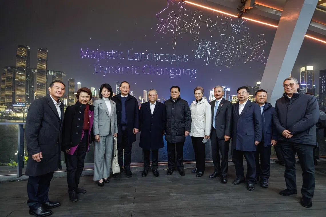 副总理兼贸工部长颜金勇一行星期一（12月15日）晚间在重庆市规划展览馆，观看纪念新中建交35周年和中新（重庆）战略性互联互通示范性项目10周年的无人机表演后，与中共重庆市委书记袁家军和重庆市长胡衡华合影。左起是数码发展及新闻部兼卫生部高级政务部长陈杰豪，贸工部兼文化、社区及青年部高级政务部长刘燕玲，交通部兼国家发展部高级政务部长孙雪玲，主管能源与科技事务的人力部长陈诗龙医生，副总理兼贸工部长颜金勇，中共重庆市委书记袁家军，数码发展及新闻部长杨莉明，外交部长维文医生，重庆市长胡衡华，教育部长李智陞，重庆市副市长徐建。（数码发展及新闻部提供）