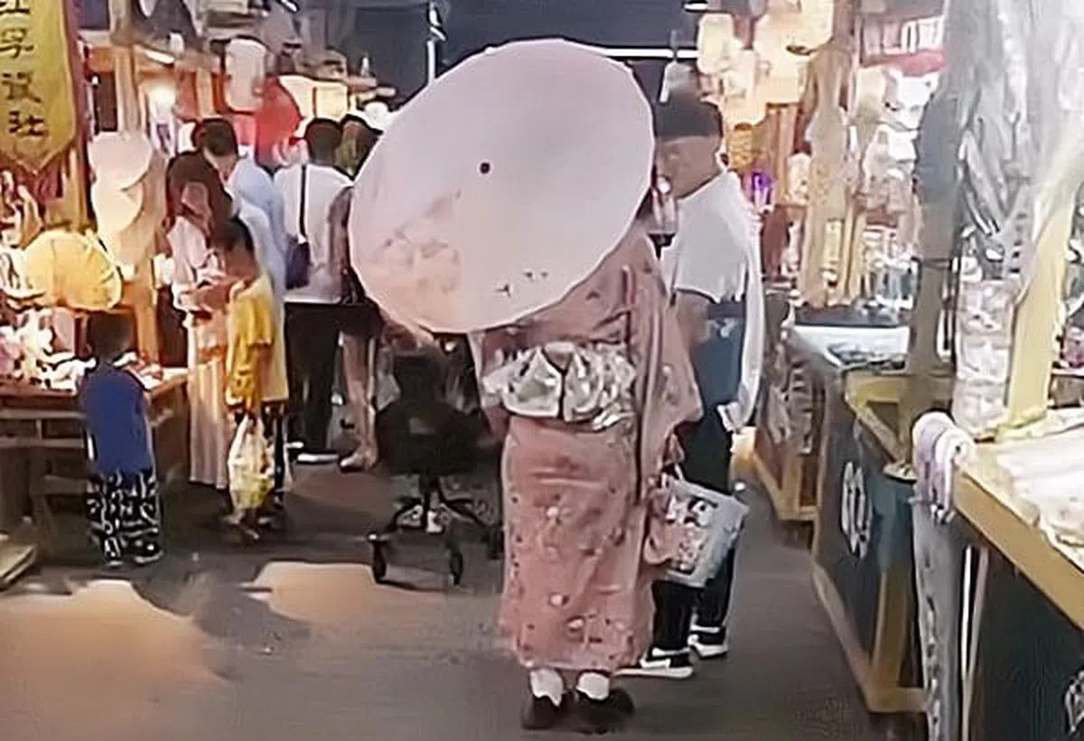 一名女子上月18日穿着和服、撑着纸伞在南京夫子庙逛街，遭到网民一面倒的指责。（互联网）