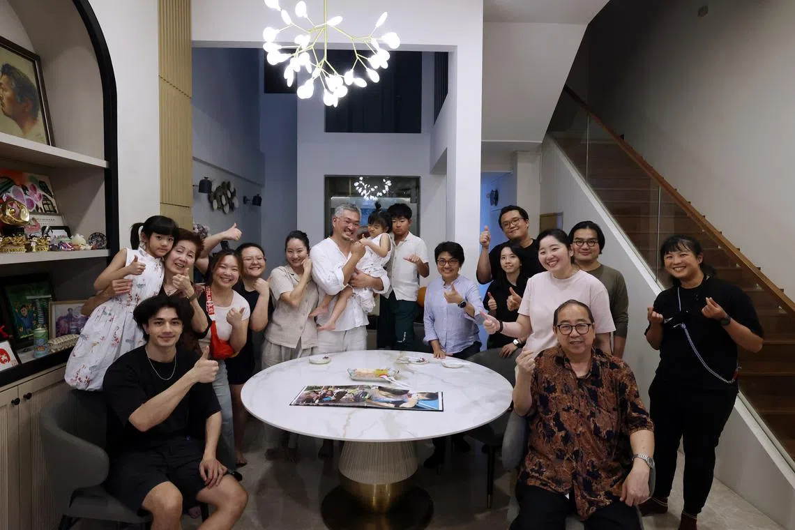 编导（桌后蓝色长袖衣者）和总导演廖捷凯（后排右二）、蔡宝祯（后排右三）与严众莲（后排左二）一家合影留念。（梁麒麟摄）