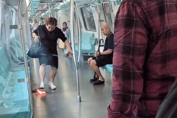 根据网上流传的视频，一名身穿黑裙的女子正试图反复踩灭地上的小火团，经过几次尝试后，终于把火踩灭。（取自网络）