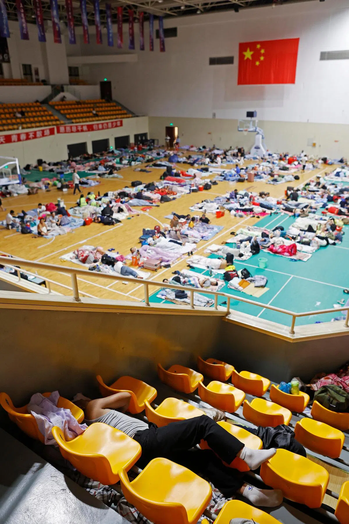 在上海临港新片区工作的员工被转移至上海建桥学院体育馆后，昨晚在体育馆内休息。（中新社）