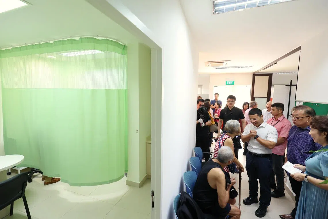 也是西海岸集选区议员的国家发展部长李智陞（白衬衫）在诊所内与居民打招呼。（何家俊摄）