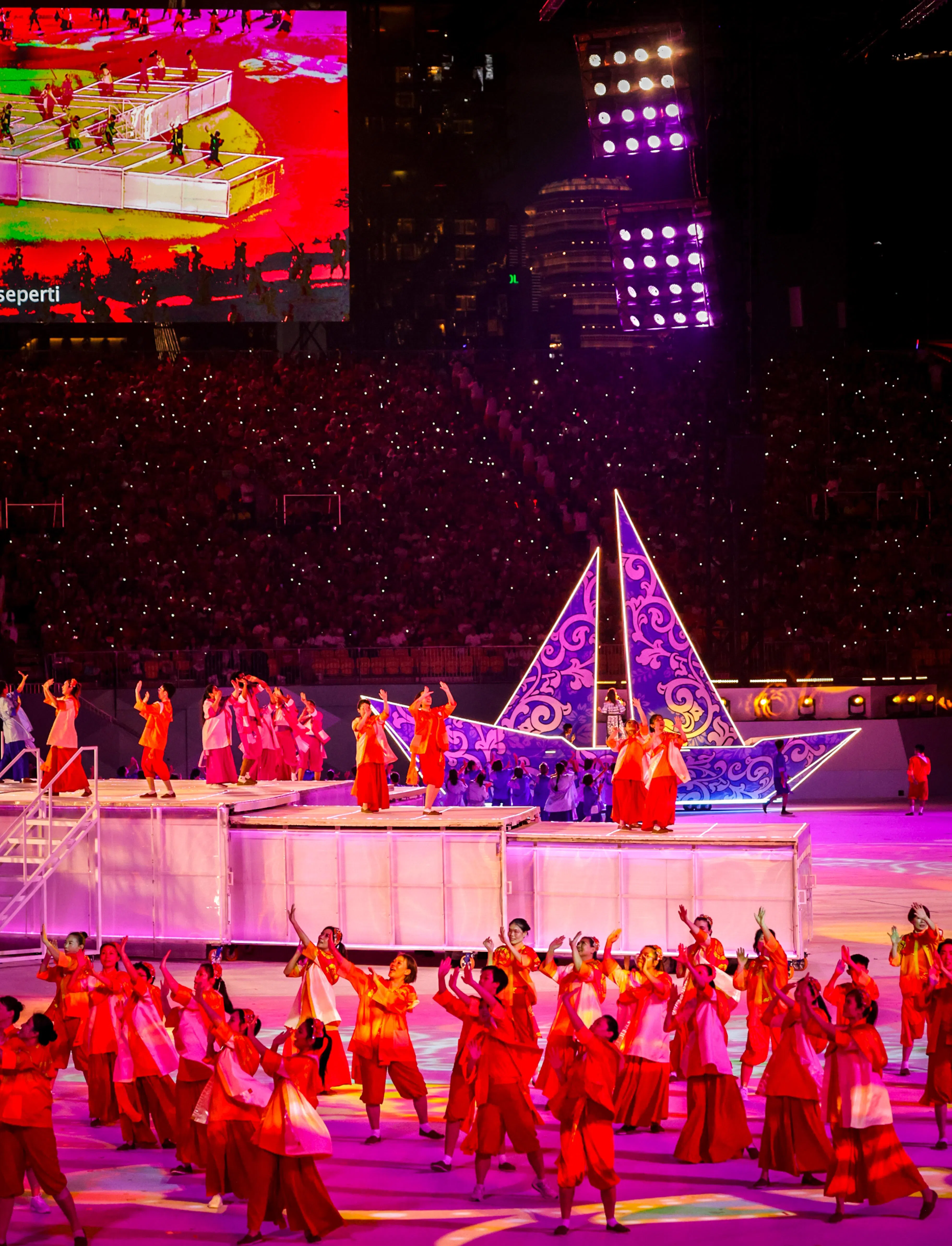 暮色降临，主办方用灯光、投影和小船花车等元素增添舞台效果。（叶振忠摄）