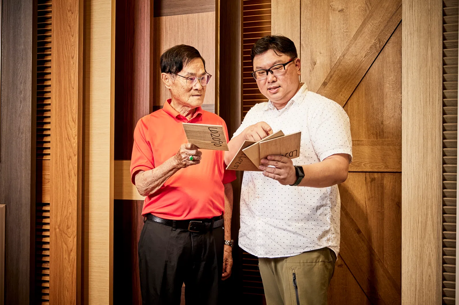 何茂松（图左）表示，他的祖籍是台湾高雄，父亲是木匠，他从小耳濡目染，少时来新打拼因此选择最熟悉的木品事业，并成功在本地扎根生儿育女，如今已将生意交给儿子何明修（图右）。（图/新报业媒体）